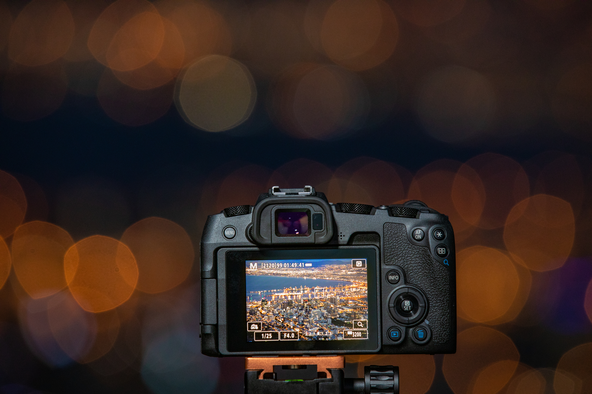 Eine Kamera, die einen Bildschirm mit Stadtansicht zeigt, mit Bokeh-Lichtern.