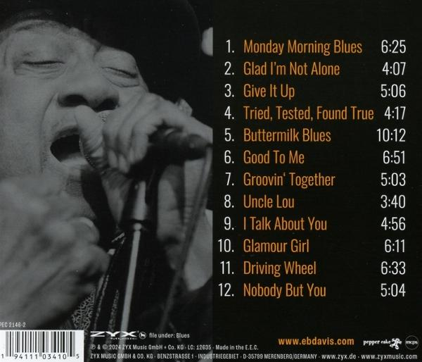Mann singt in ein Mikrofon, Albumcover mit Titelliste.