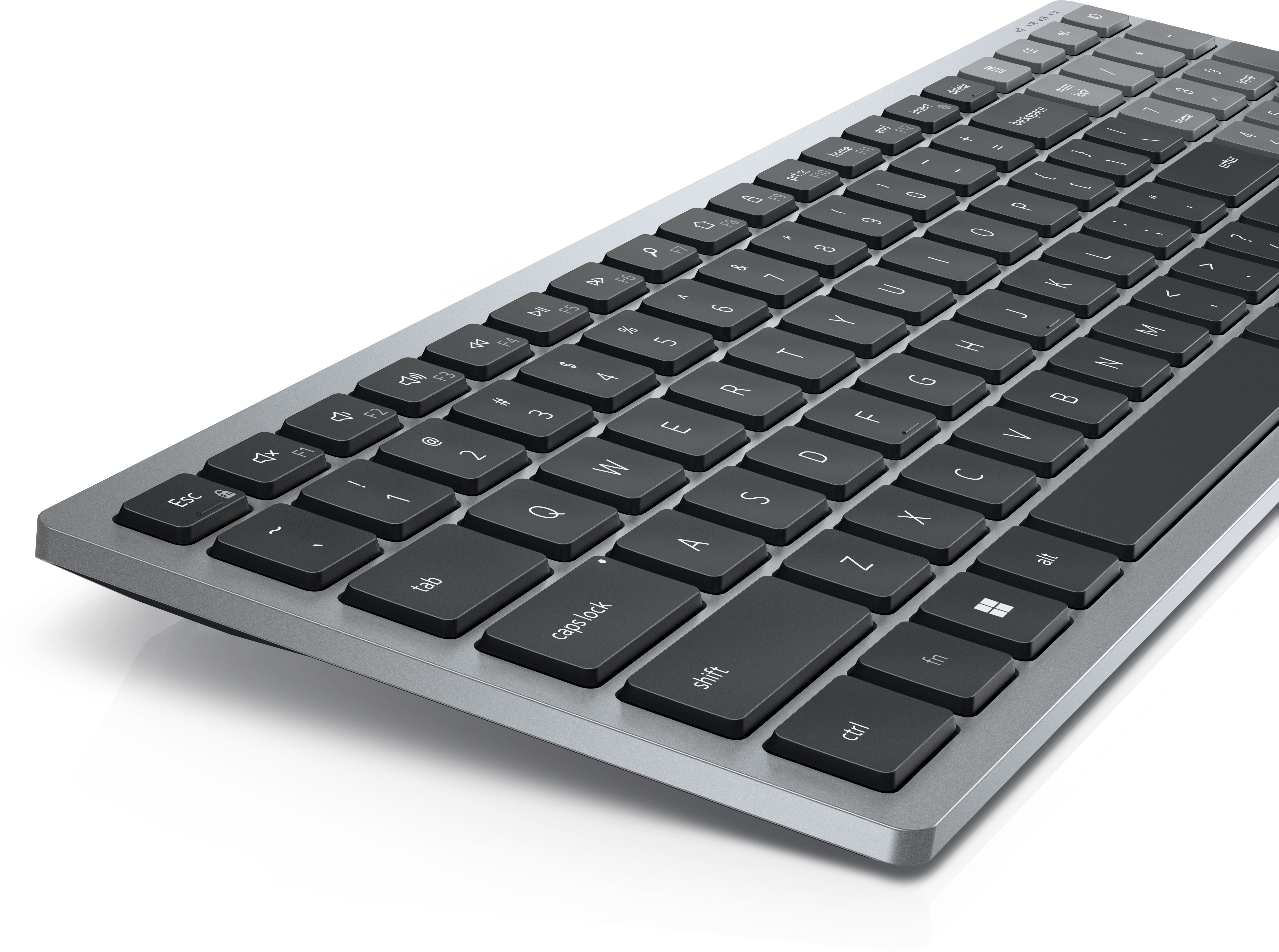 Nahaufnahme einer grauen Tastatur mit schwarzen Tasten. Die Tastatur ist abgewinkelt, Tasten mit Buchstaben und Symbolen.