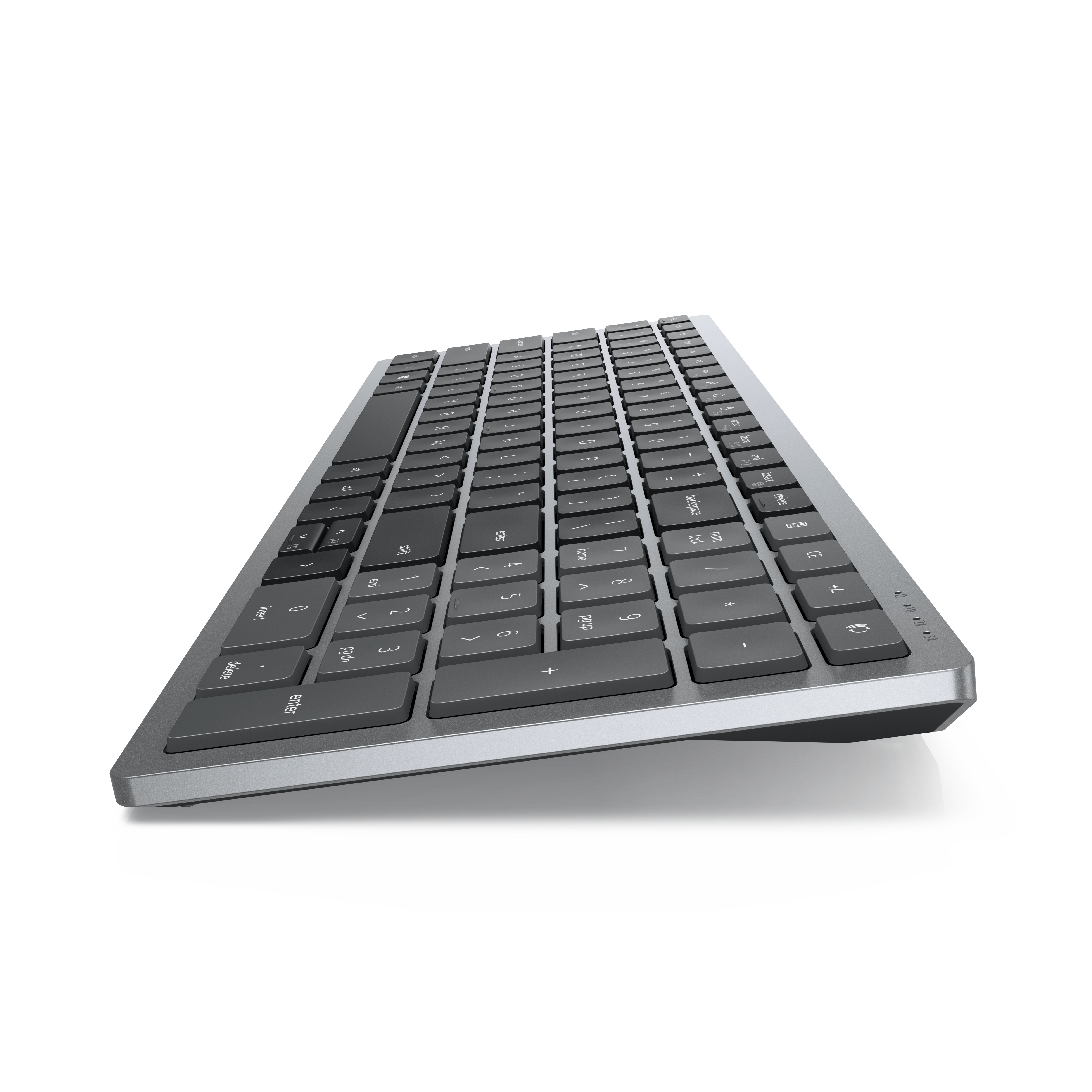 Un teclado gris en ángulo sobre un fondo blanco. Las teclas son negras.