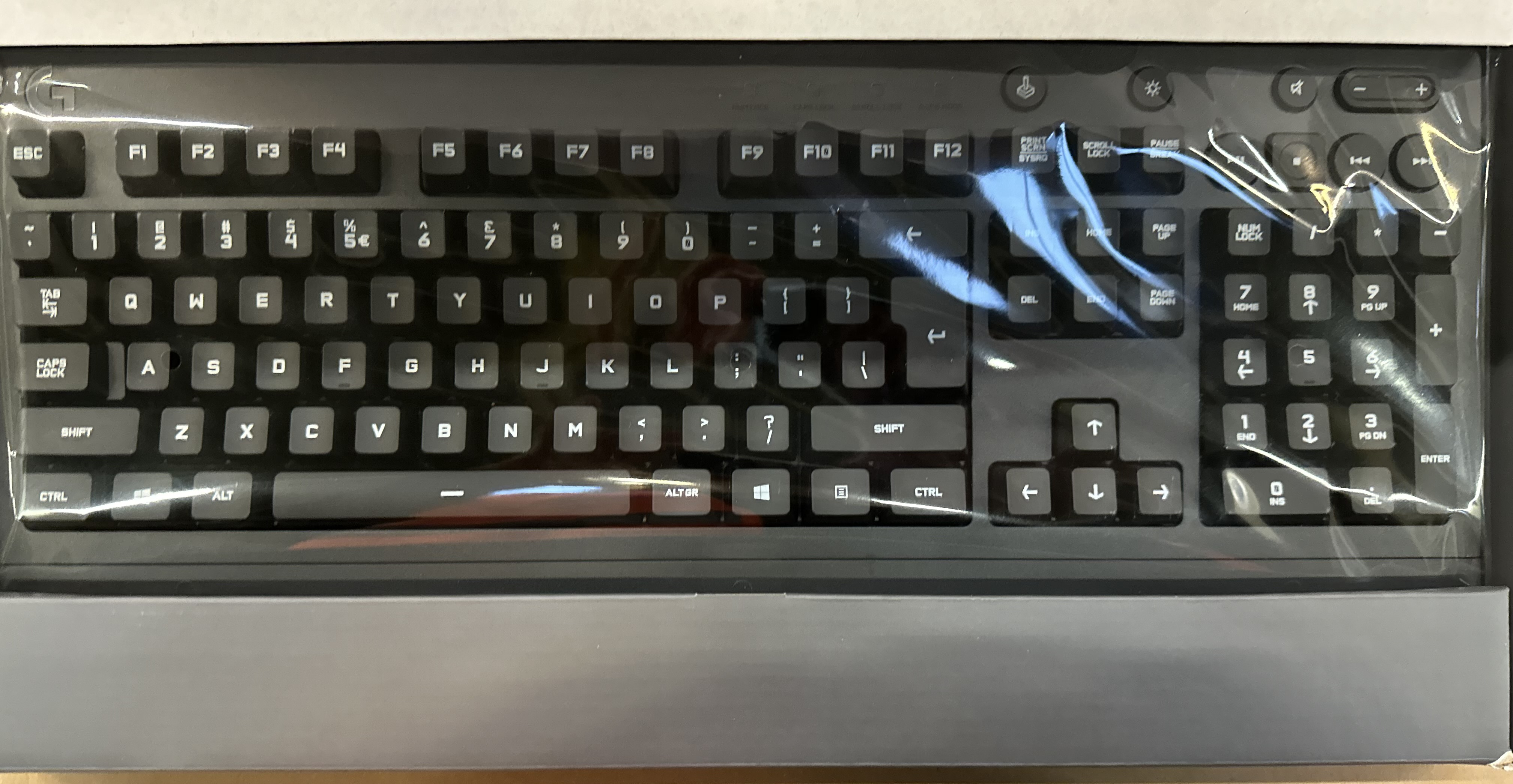 Zbliżenie czarnej klawiatury z klawiszami pod plastikiem.