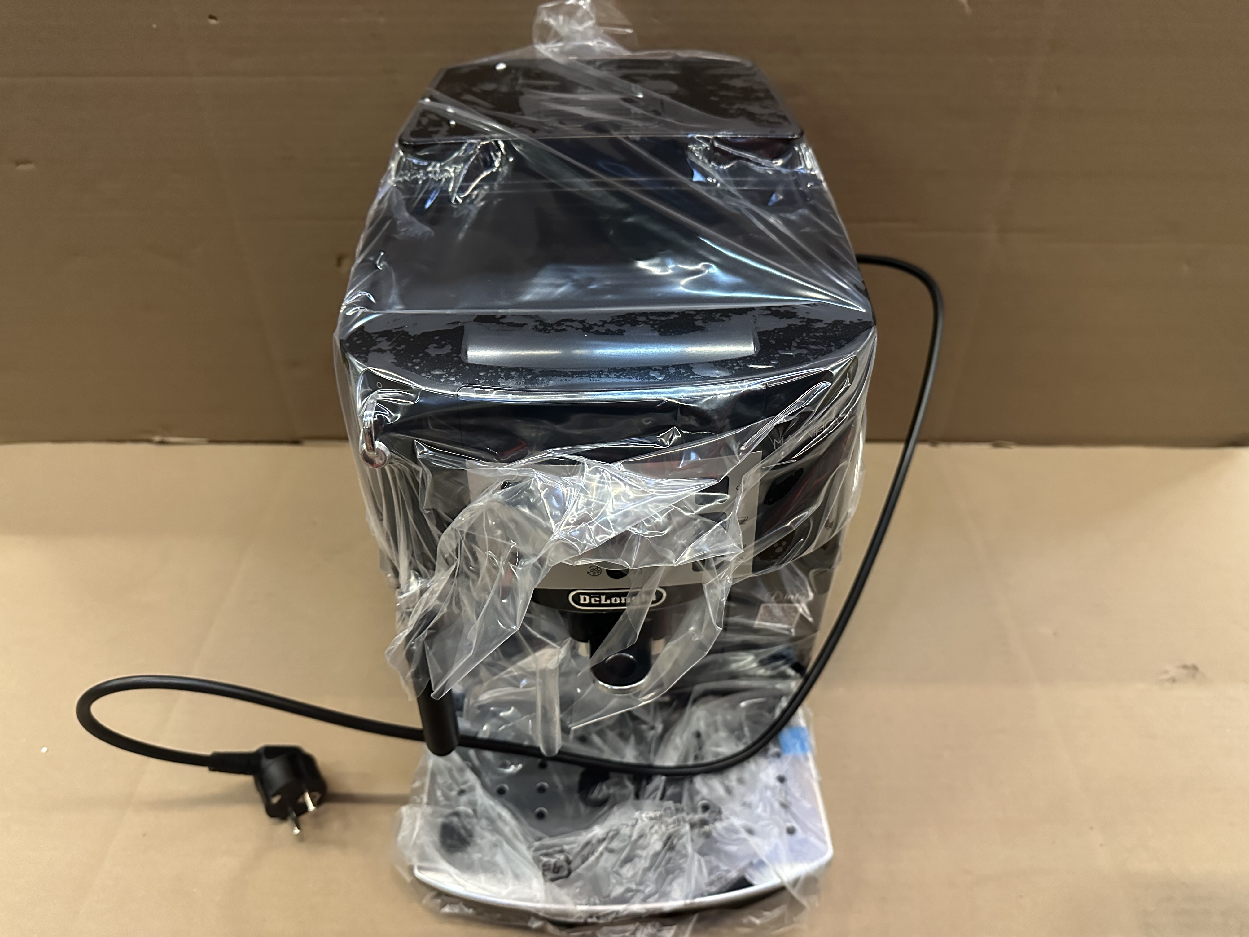 Czarny ekspres do kawy owinięty przezroczystym plastikiem.