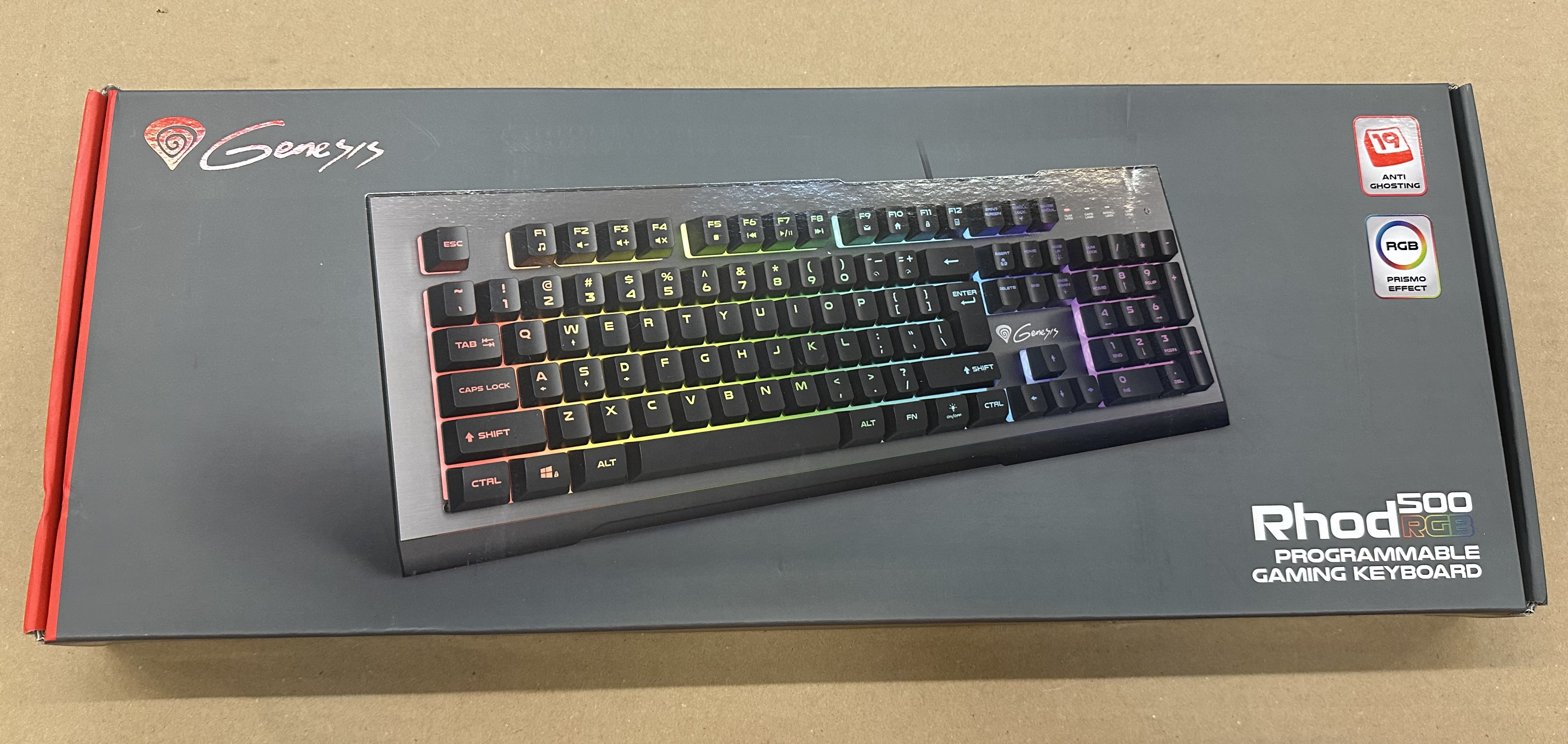 Czarna klawiatura w pudełku z kolorowymi klawiszami i logo Genesis. Pudełko ma kolory czerwony i czarny.