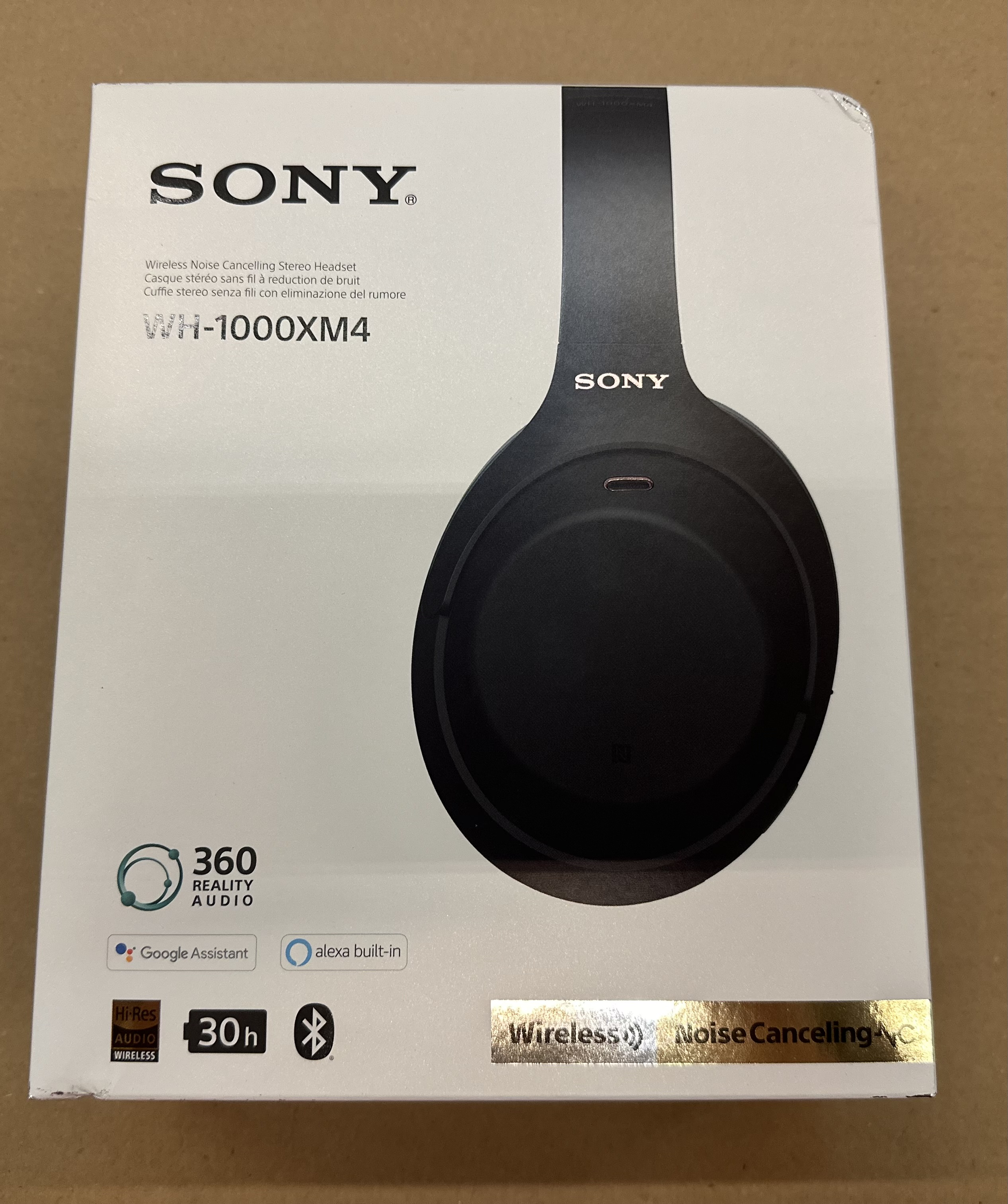 Pudełko słuchawek Sony WH-1000XM4. Czarny obraz słuchawek na białym tle. Wyświetlane są funkcje i marka.