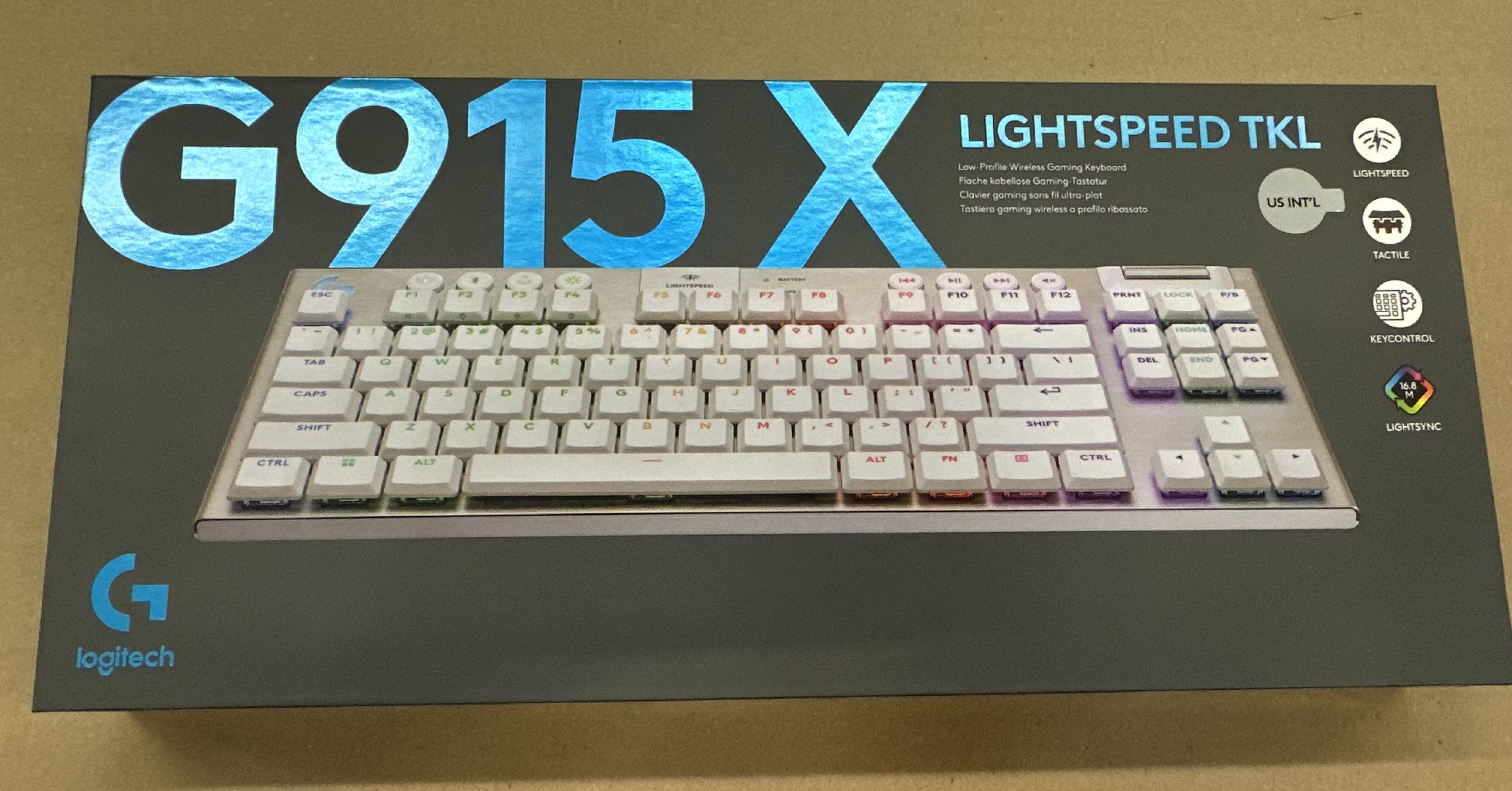 Pudełko klawiatury Logitech G915 X Lightspeed TKL. Klawiatura jest widoczna, białe klawisze i efekty świetlne.