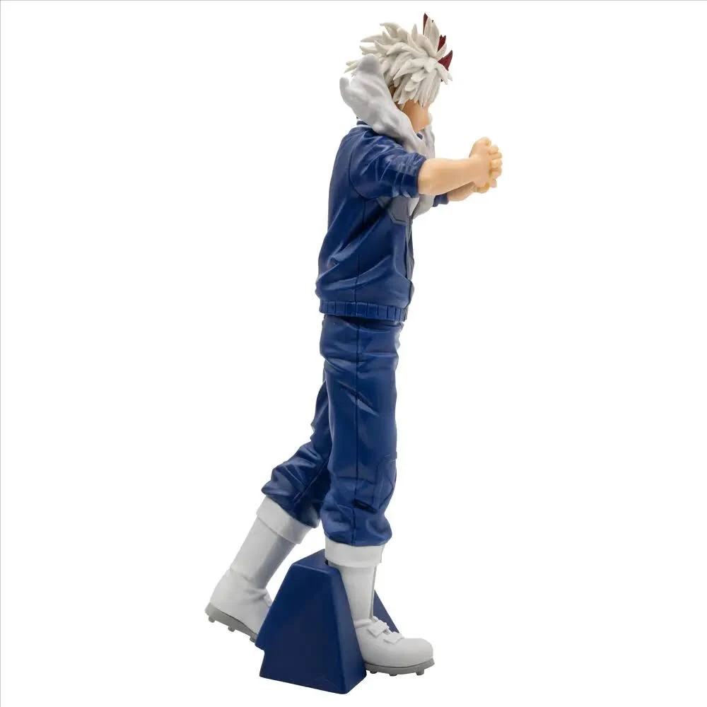 Figura de personaje en traje azul, pelo blanco y botas, de pie sobre un bloque azul, aislado sobre fondo blanco.