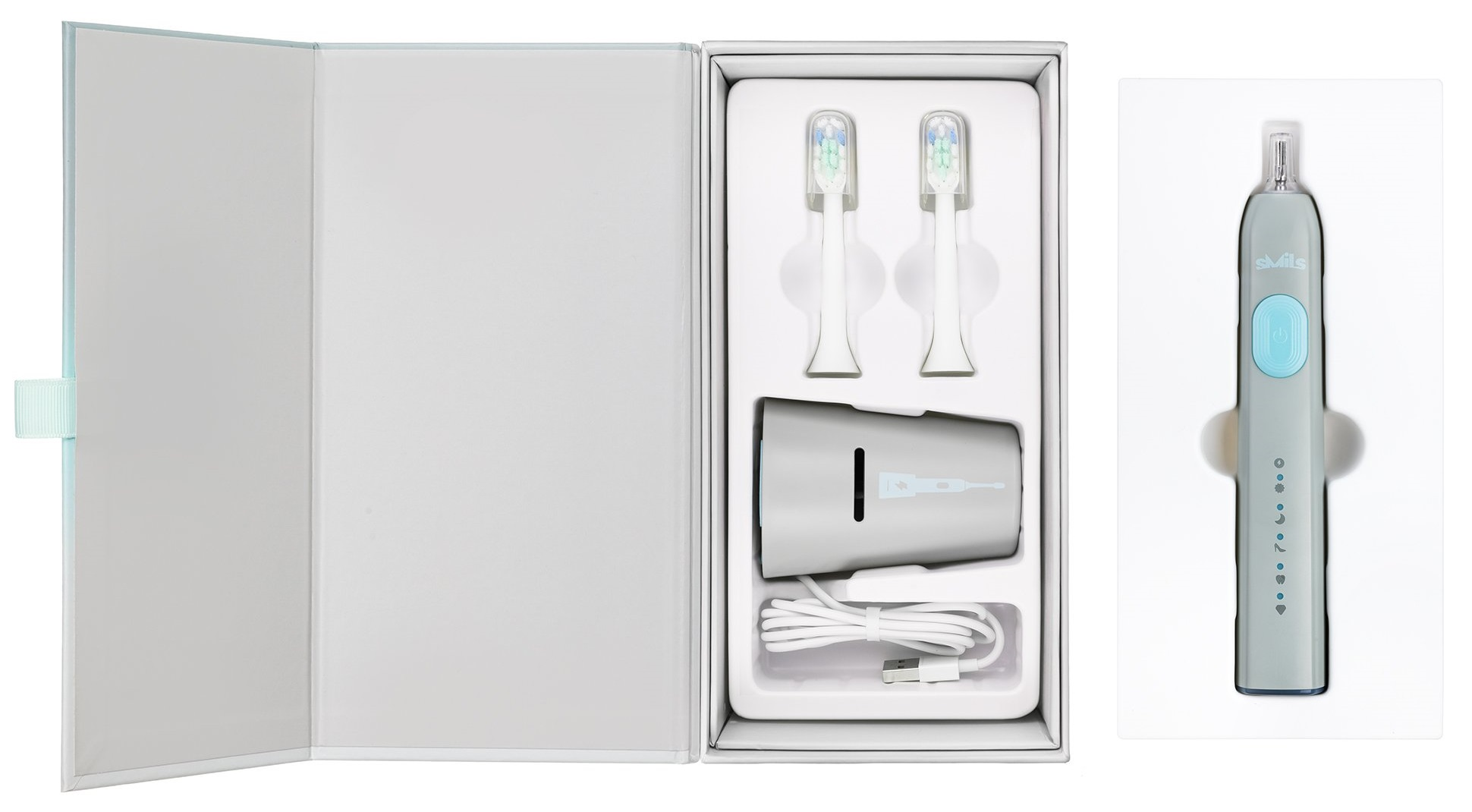 Otwarte pudełko ze szczoteczką do zębów, ładowarką i dwiema końcówkami. Widoczna jest również osobna szczoteczka.