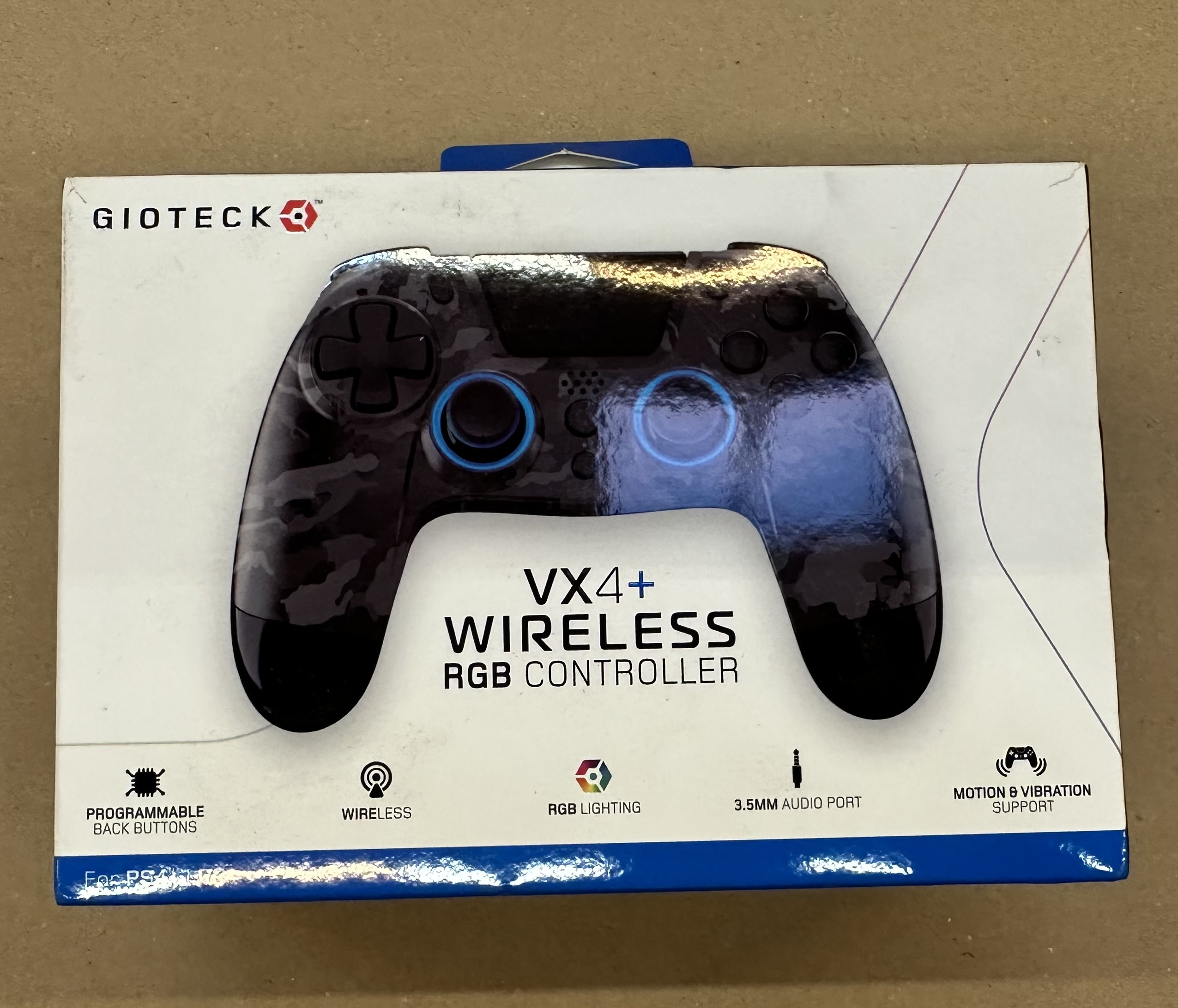 Pudełko kontrolera RGB bezprzewodowego GIOTECK VX4+. Kontroler ma wzór kamuflażu. Cechy: Programowalne przyciski, bezprzewodowy.