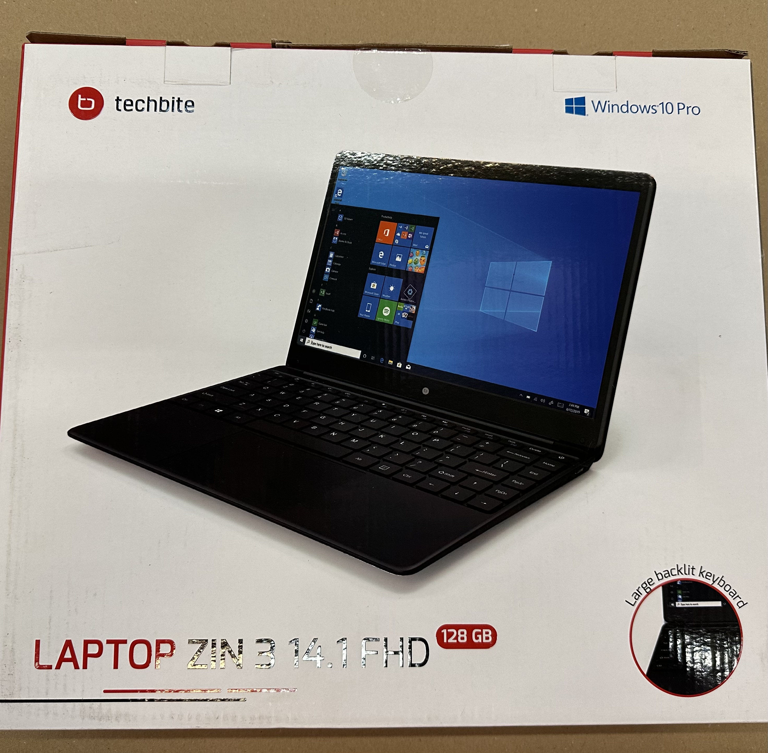 Laptop w pudełku, z czarnym ekranem i klawiaturą.