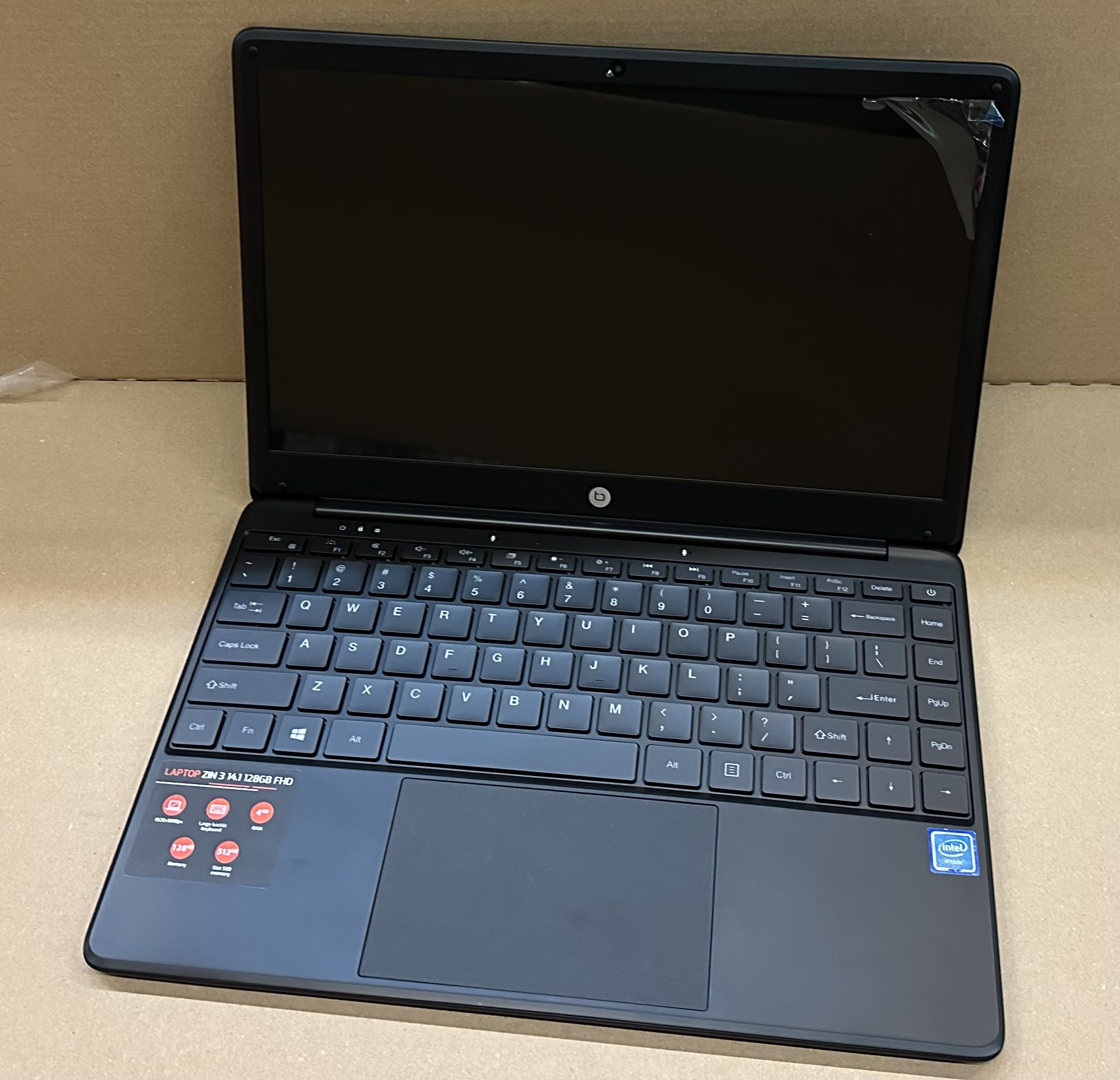 Czarny laptop, otwarty, pokazujący ekran i klawiaturę.