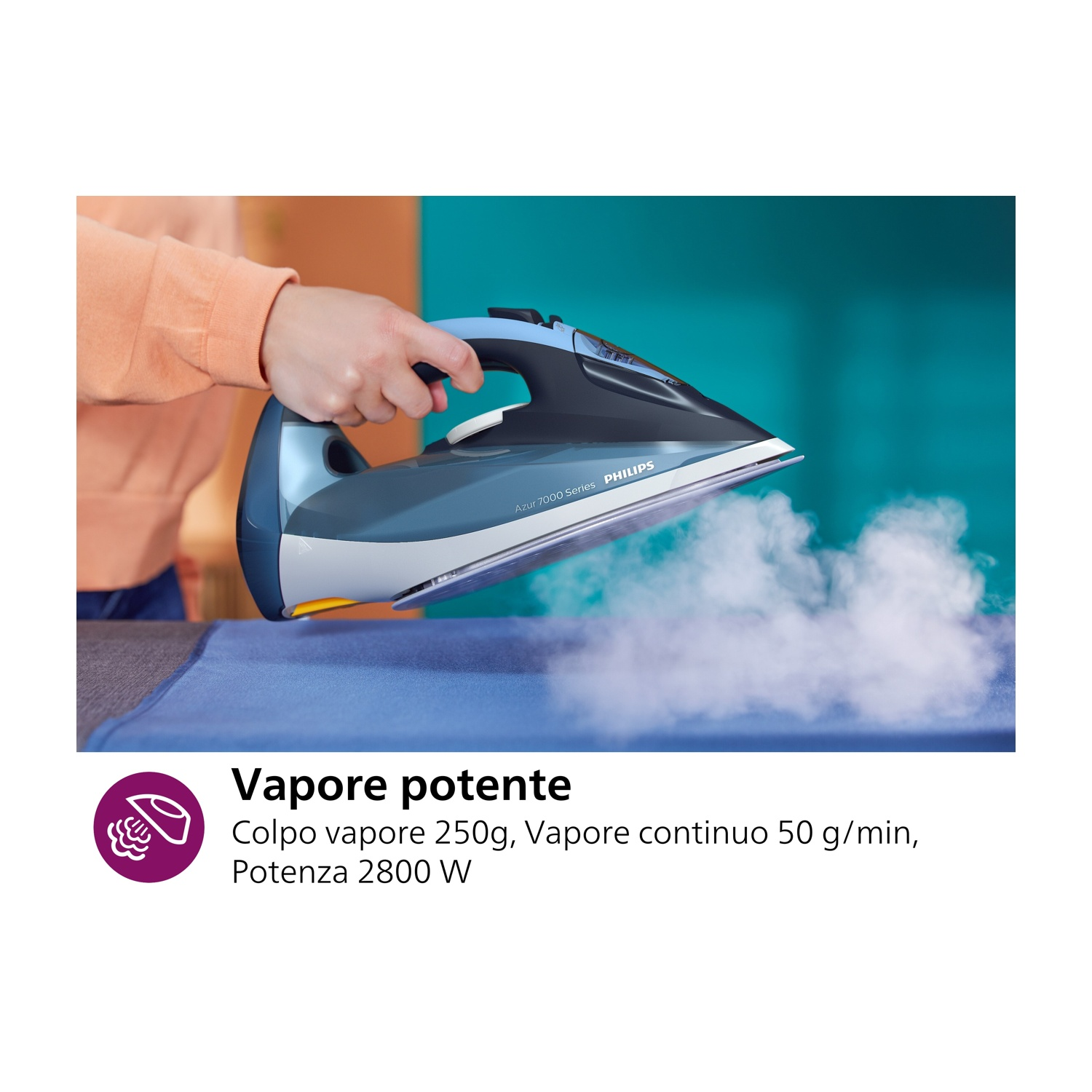 Mano di una persona che stira tessuto blu con un ferro da stiro Philips, vapore visibile.