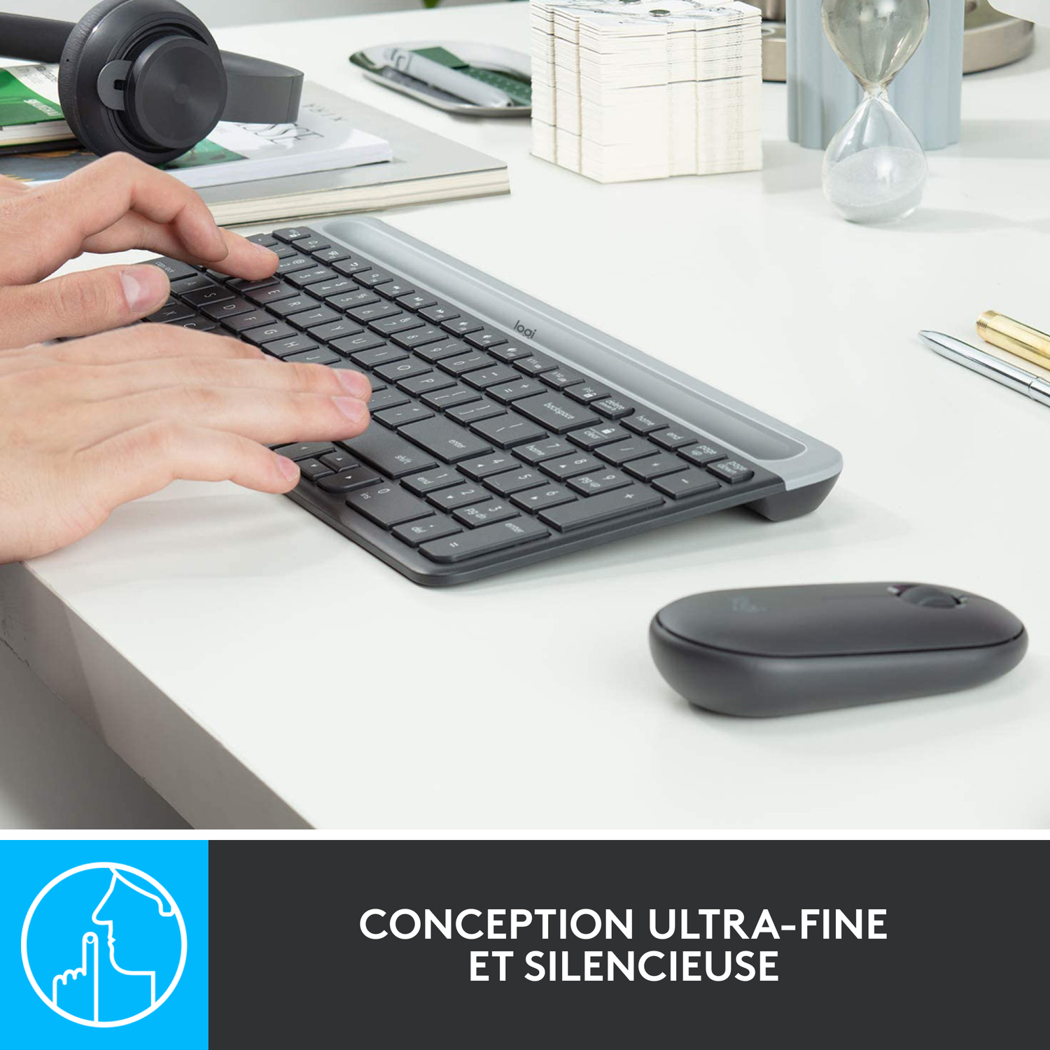 Mains tapant sur un clavier, avec une souris sur un bureau blanc.