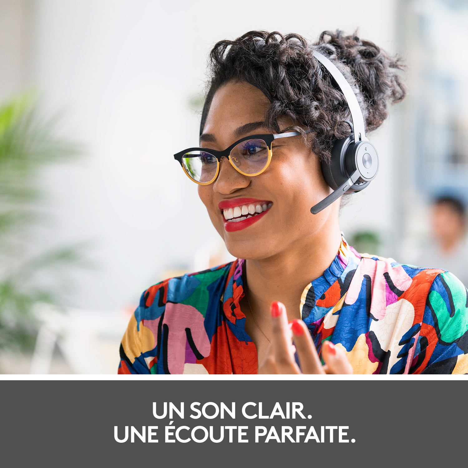 Femme avec casque sourit; chemise colorée. Texte: Son clair. Une écoute parfaite.