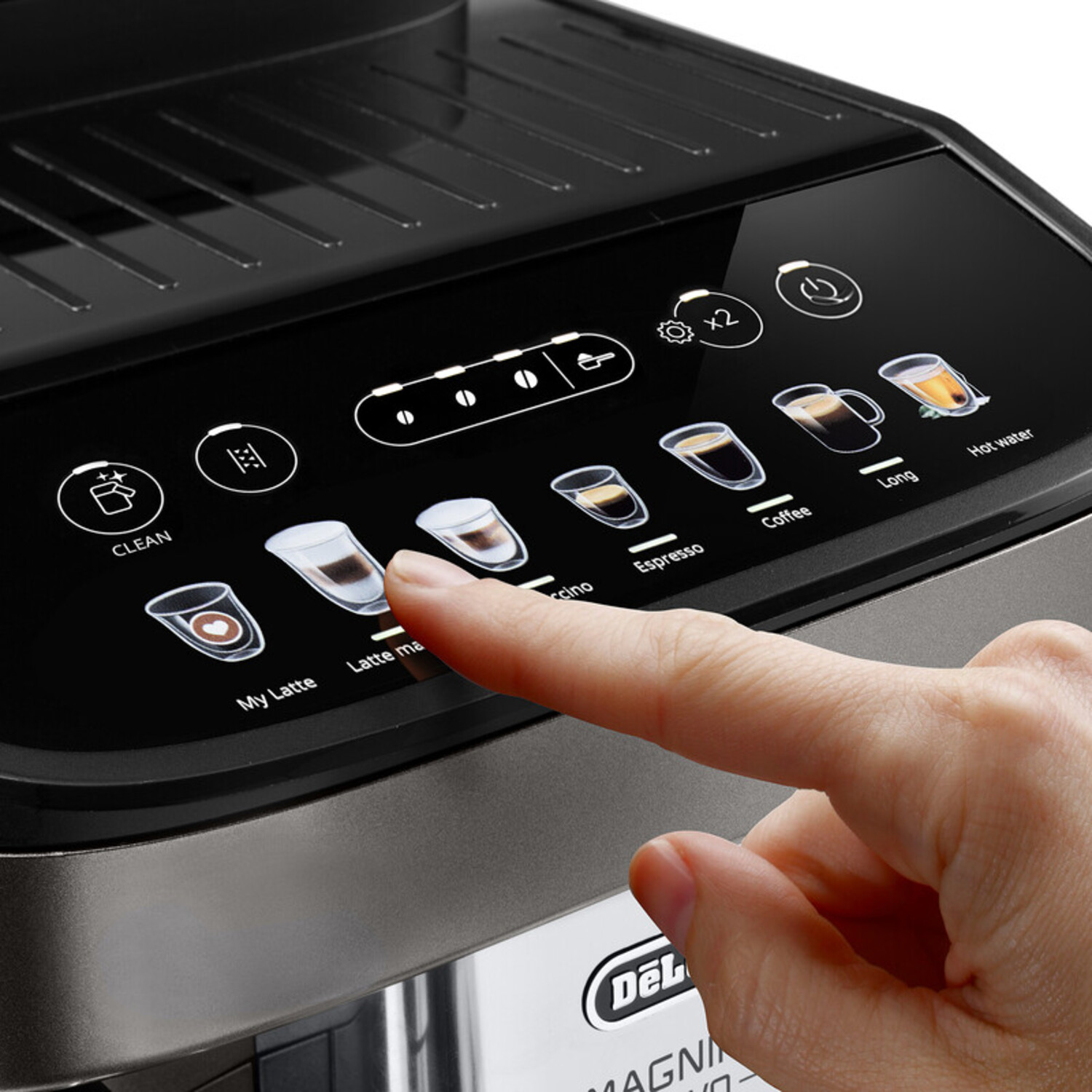 Hand touching coffee machine screen. Shows Latte Macchiato option. Text: Magnifica EVO.