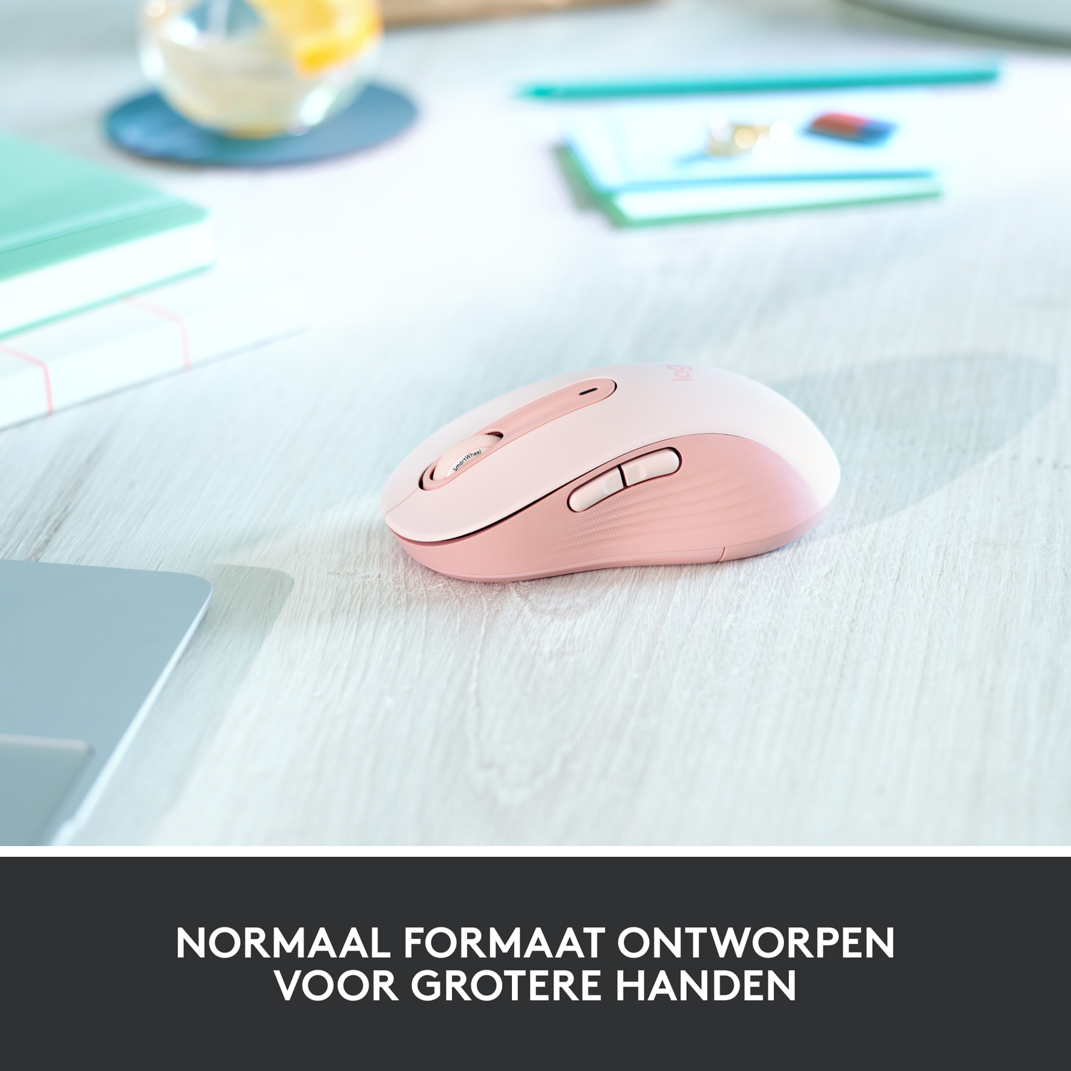 Pink Logitech mouse on a wooden surface. The mouse is designed for larger hands.