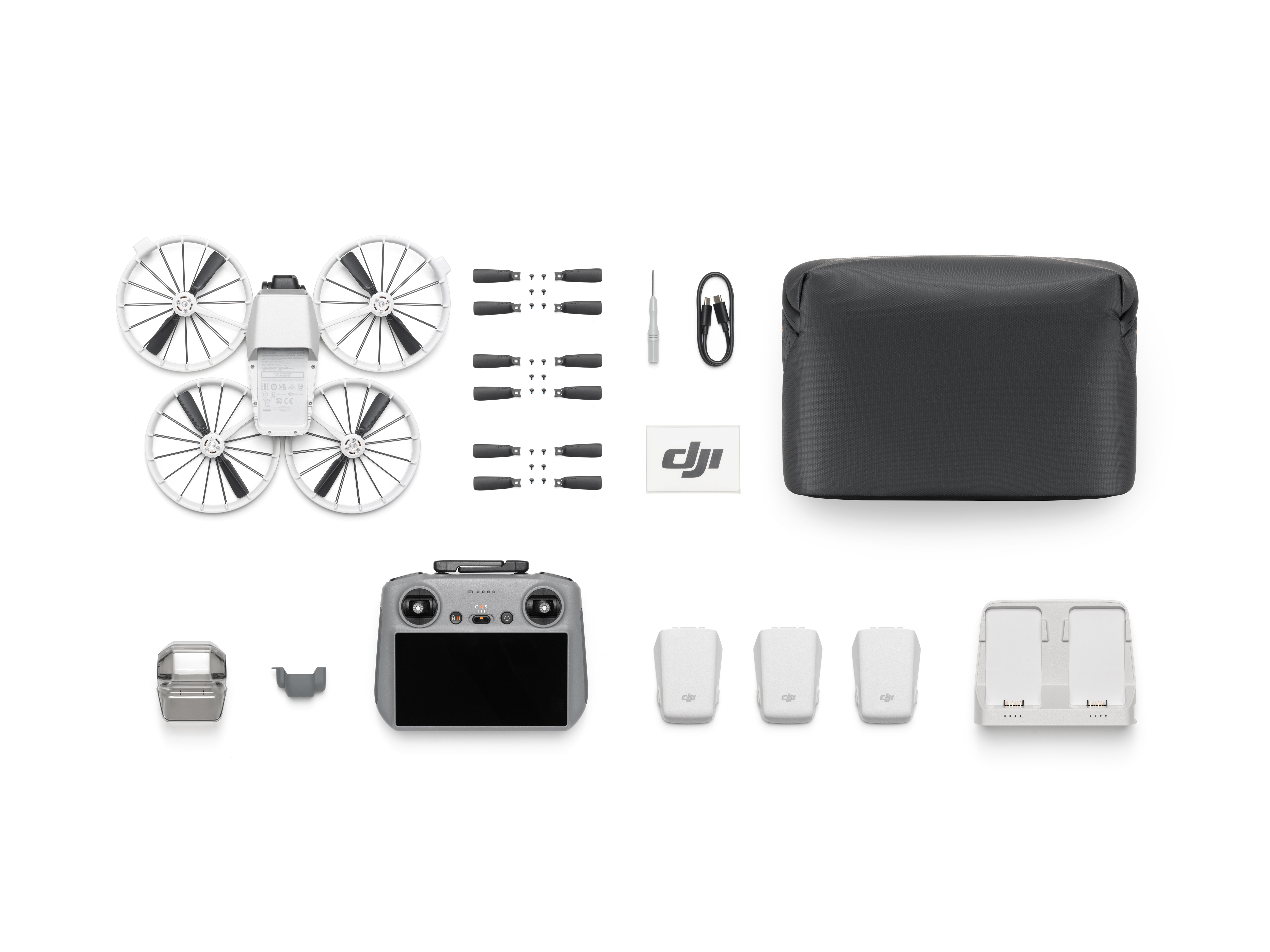 Eine Drohne und ihr Zubehör, einschließlich Fernbedienung, Akkus und einer Tragetasche.