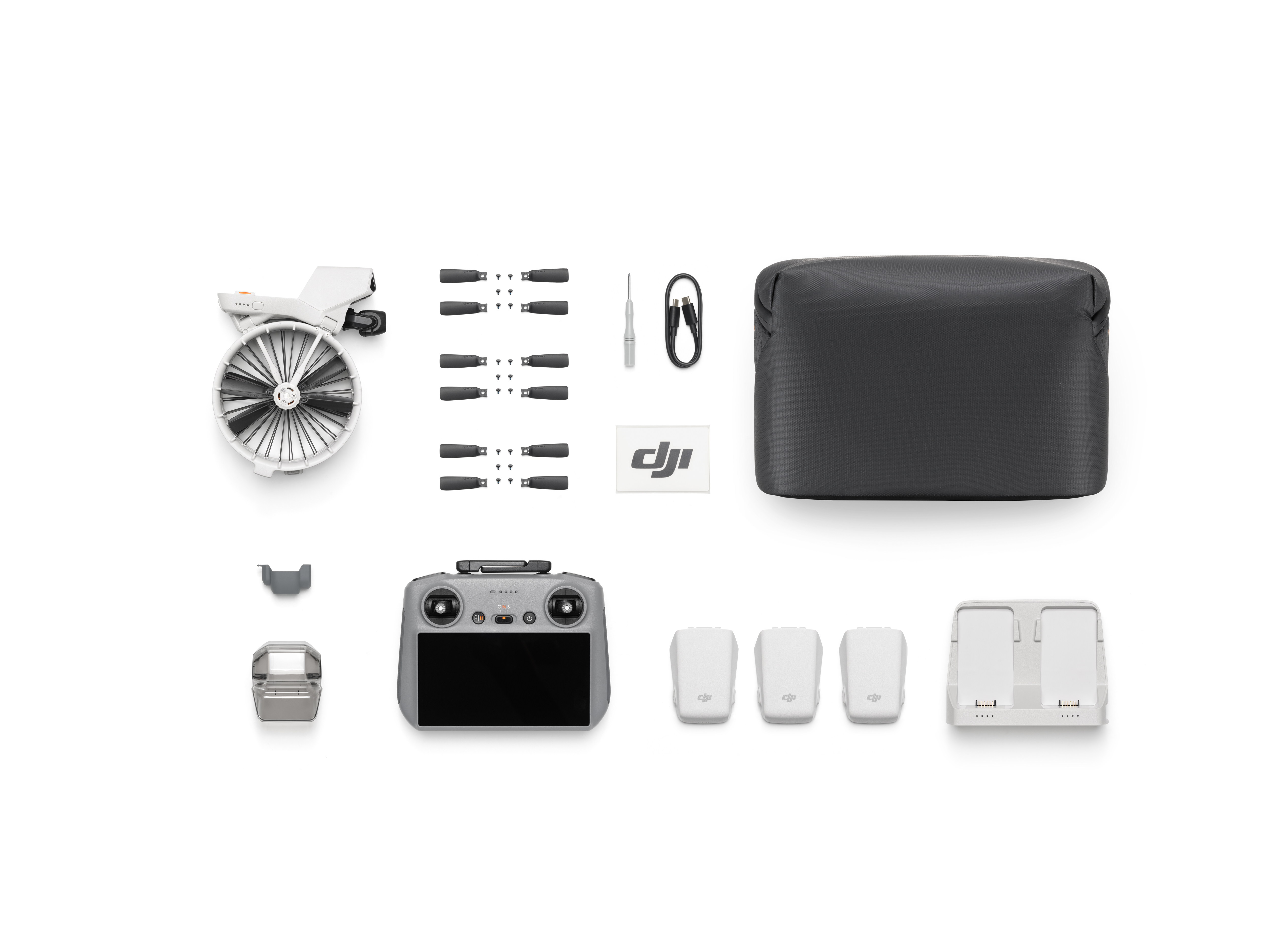 Drohnen-Kit-Komponenten auf Weiß. Drohne, Controller, Akkus, Ladegerät, Props, Schraubendreher, DJI Logo, Tasche.