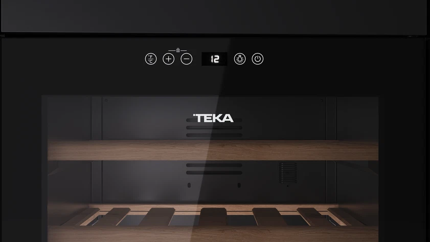 Una vinoteca Teka negra con pantalla digital que muestra 12. Estantes de madera visibles a través de la puerta de cristal.