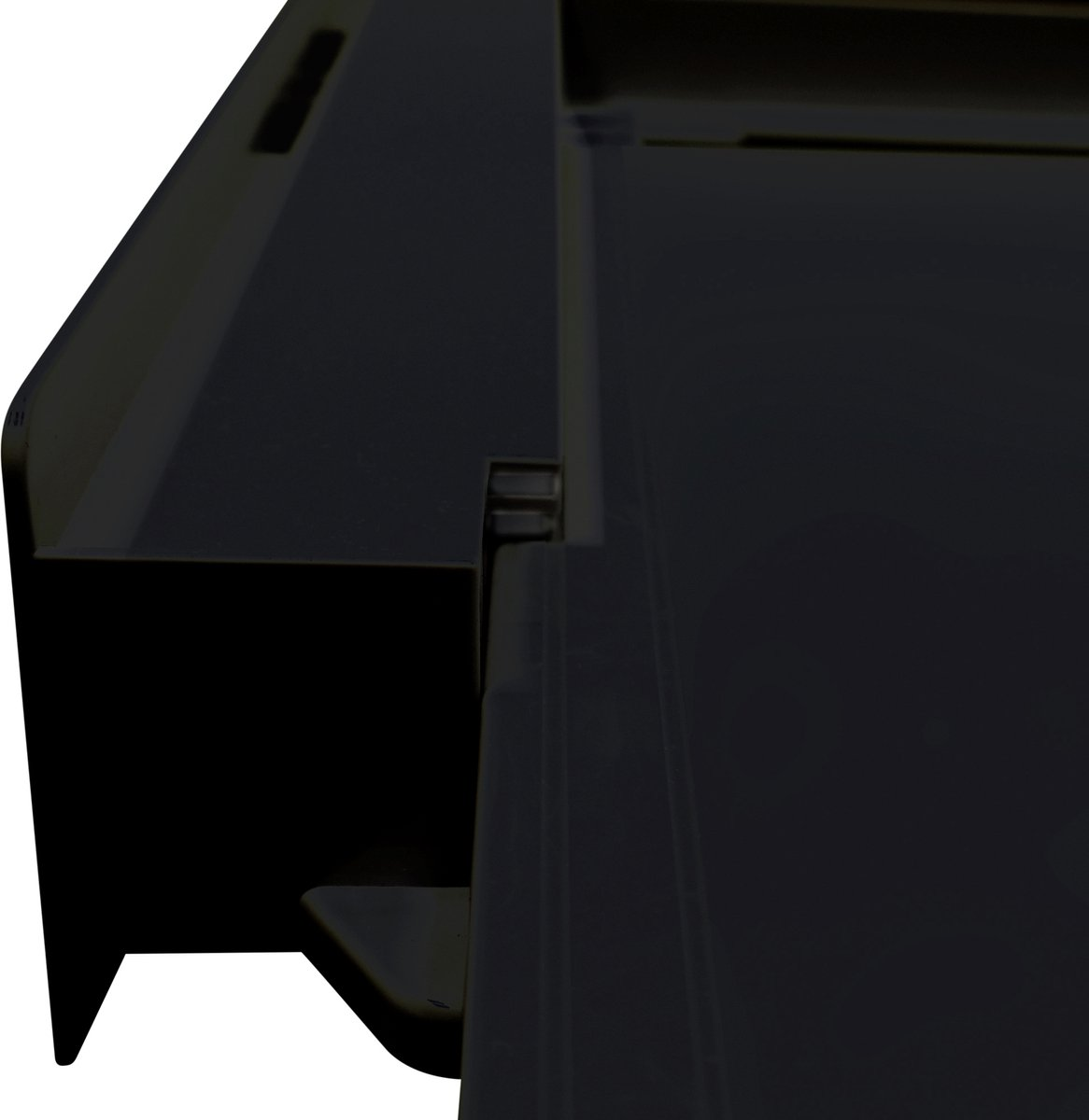 Zbliżenie czarnego plastikowego elementu. Jego powierzchnia jest gładka i ma prostokątny kształt.