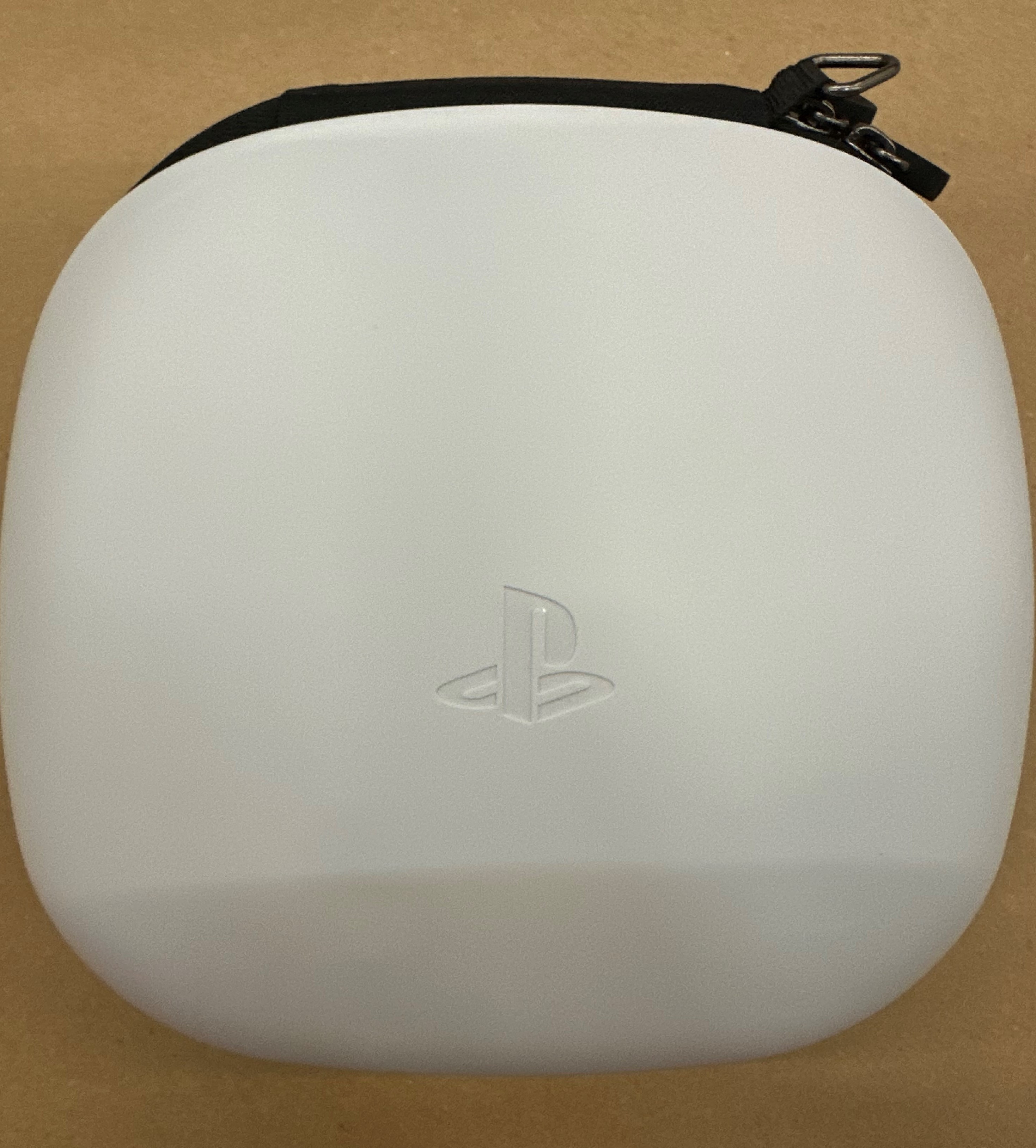 Białe etui PlayStation z czarnym paskiem. Symbol PlayStation znajduje się na środku etui.