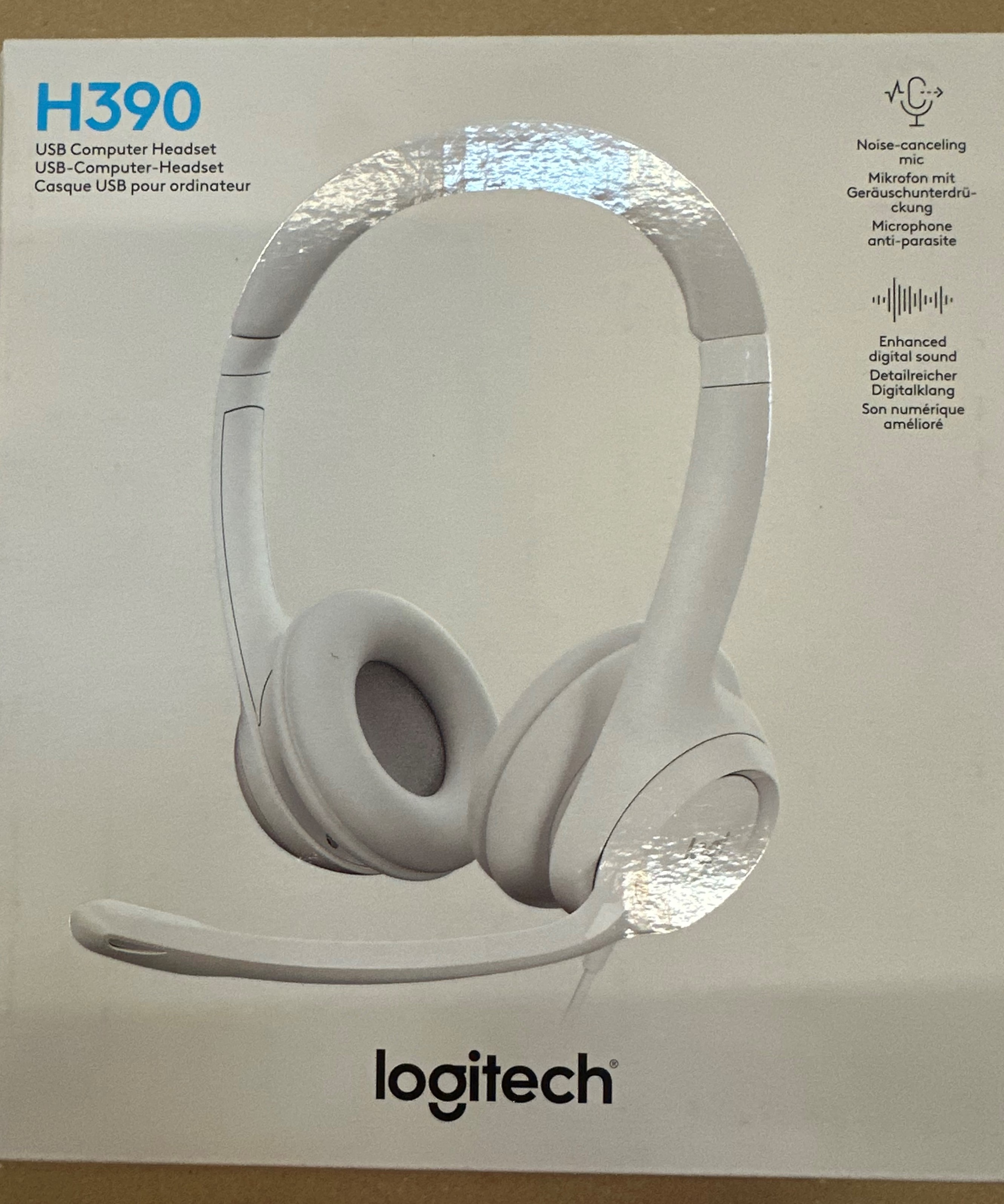 Biały zestaw słuchawkowy USB do komputera Logitech H390. Pudełko zawiera tekst i zdjęcie zestawu słuchawkowego.