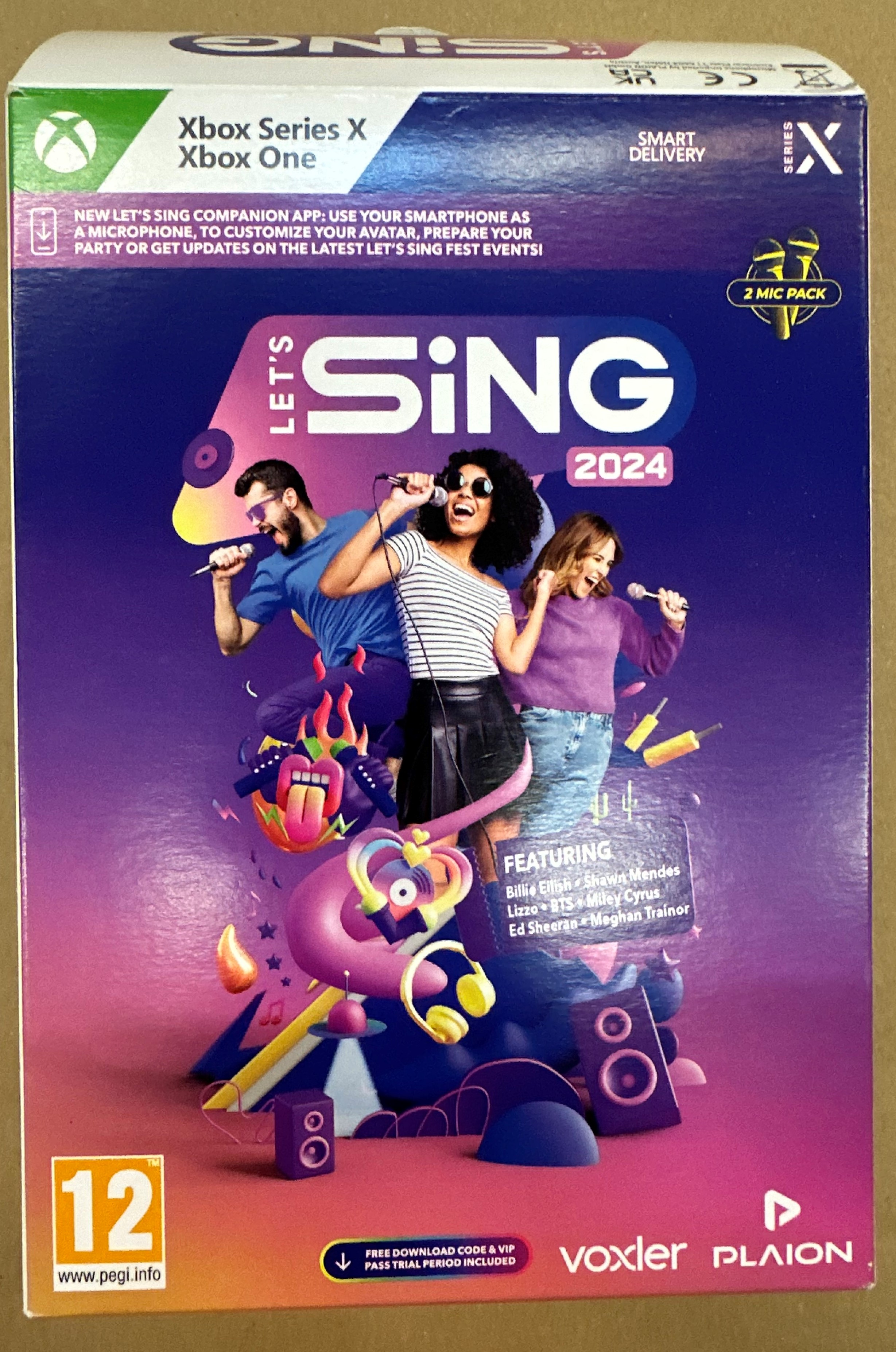 Pudełko z grą Let's Sing 2024 na Xbox Series X/Xbox One. Zawiera piosenkarzy i mikrofony. Zawiera 2 mikrofony.