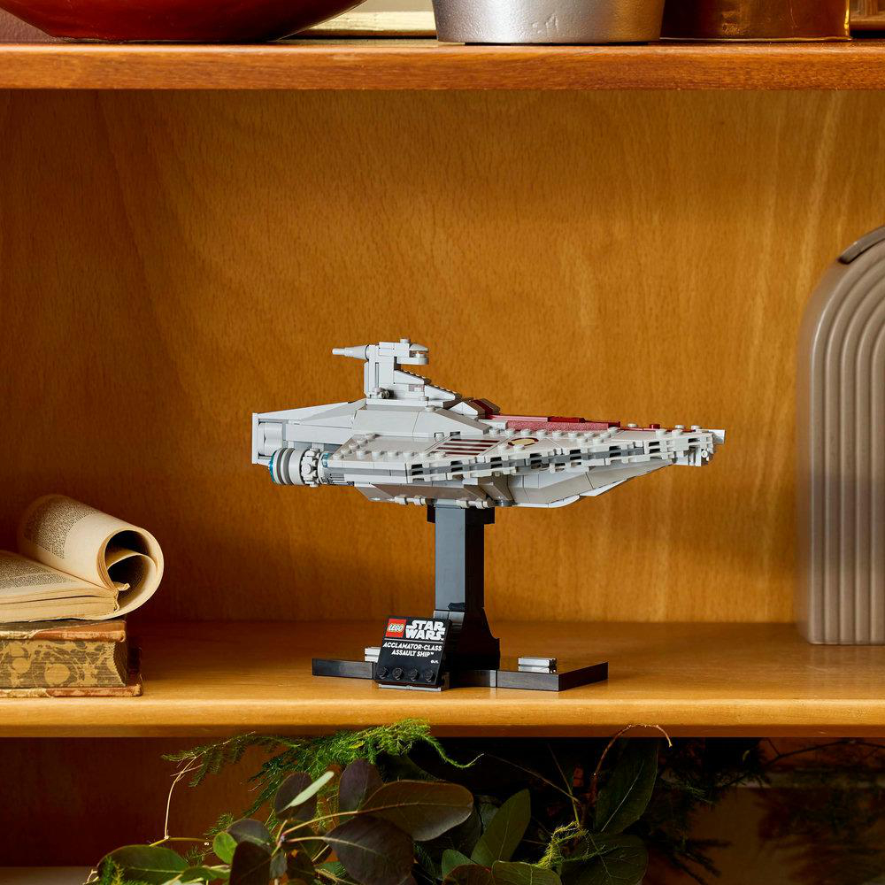 Lego Star Wars Modell eines Sternenzerstörers auf einem Holzregal, neben Büchern und Pflanzen.