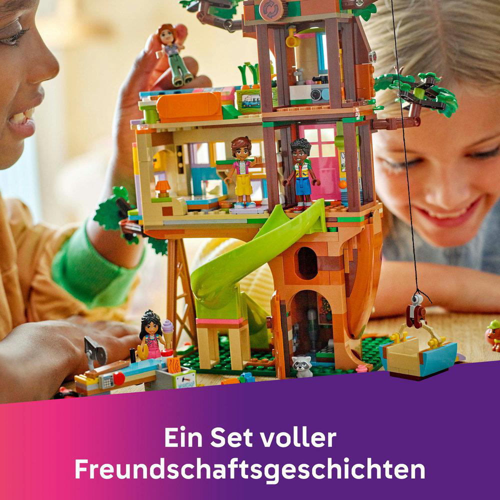 Zwei Mädchen spielen mit einem Lego-Baumhaus. Figuren, Rutsche und Baumhaus sind sichtbar.