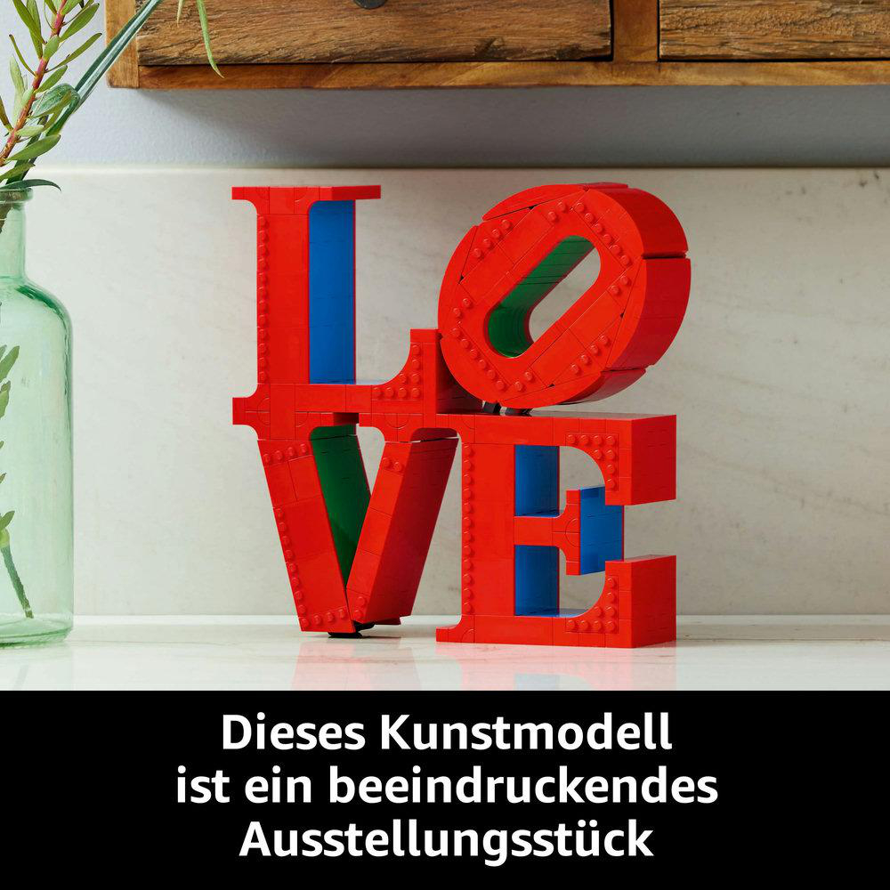 Rote LEGO LOVE-Skulptur mit blauen und grünen Blöcken. Text unten: 'Dieses Kunstmodell...'