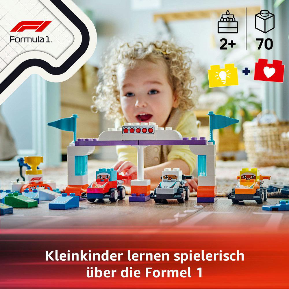 Ein Kind spielt mit Lego Formel 1 Rennwagen und einer Ziellinie.