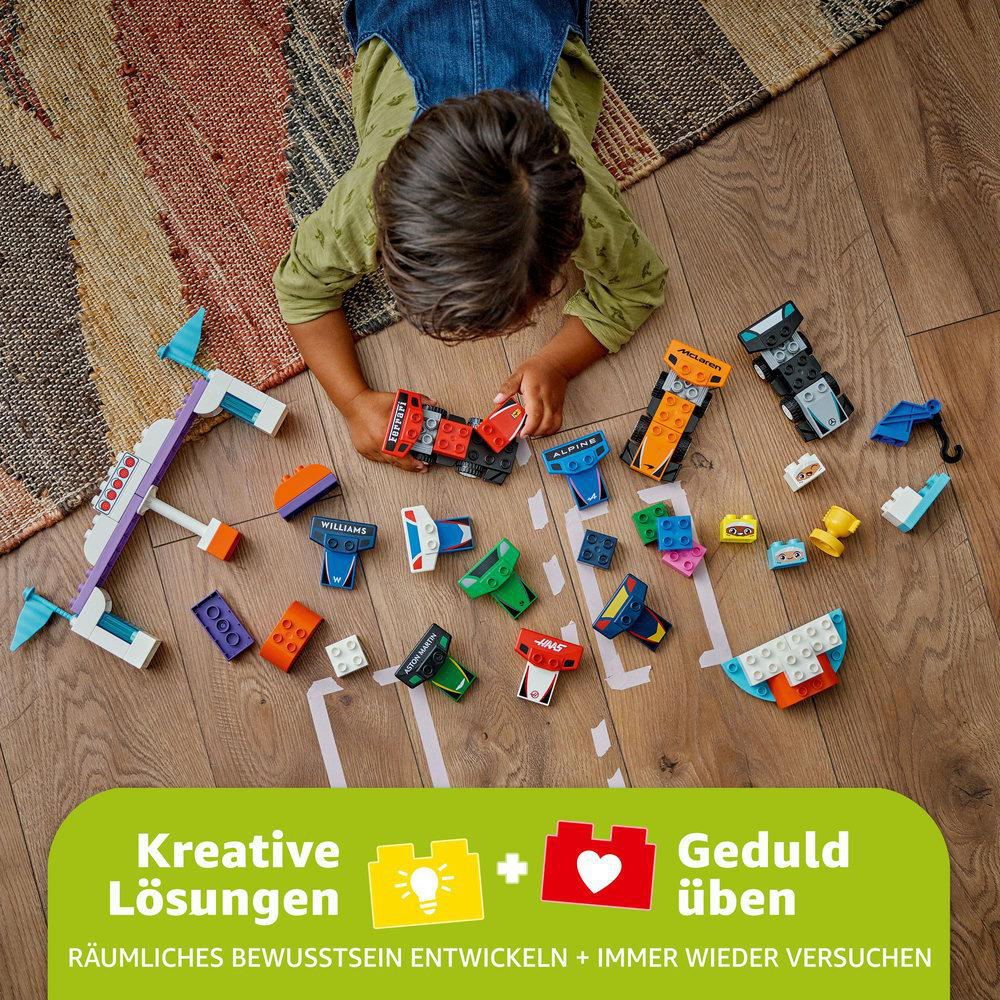 Ein Kind spielt mit Lego-Rennwagen. Verschiedenfarbige Lego-Steine liegen auf einem Teppich verstreut.
