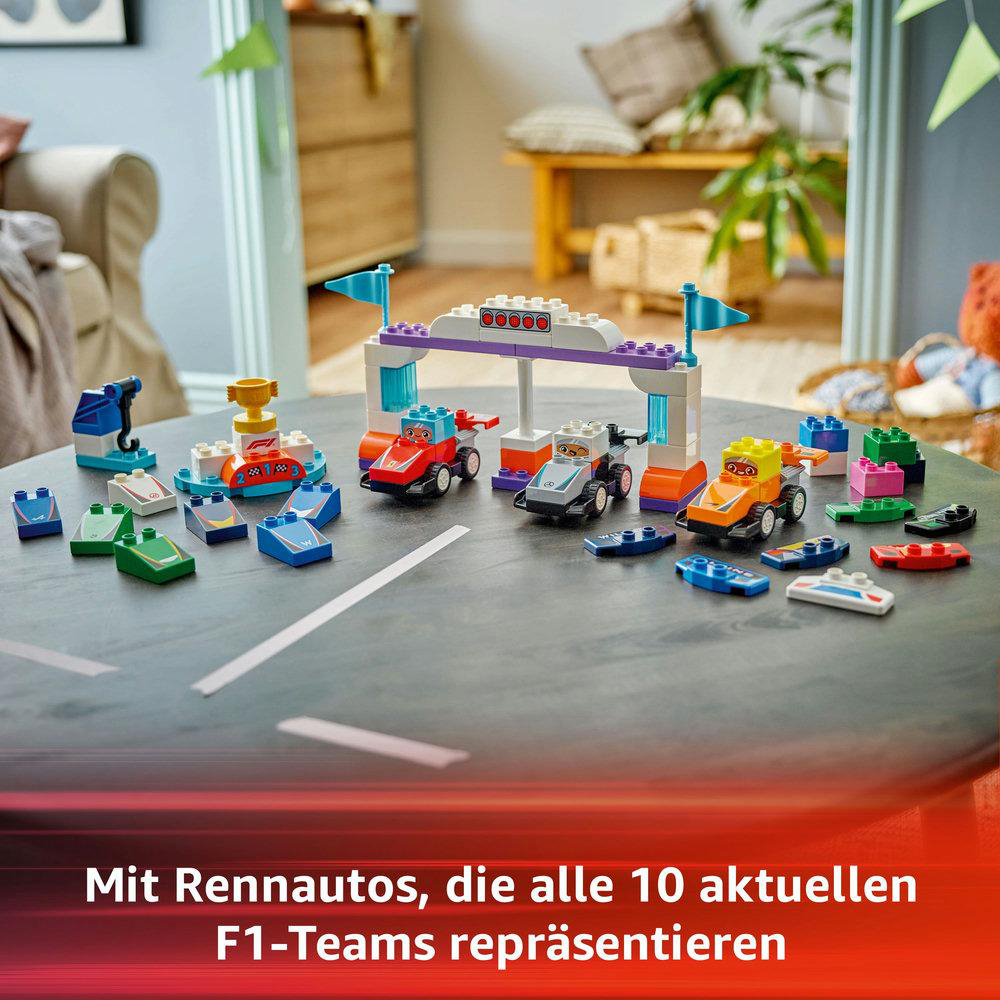 Lego-Rennwagen auf einem Tisch aufgebaut. Flaggen, Ziellinie und Lego-Steine sind sichtbar.