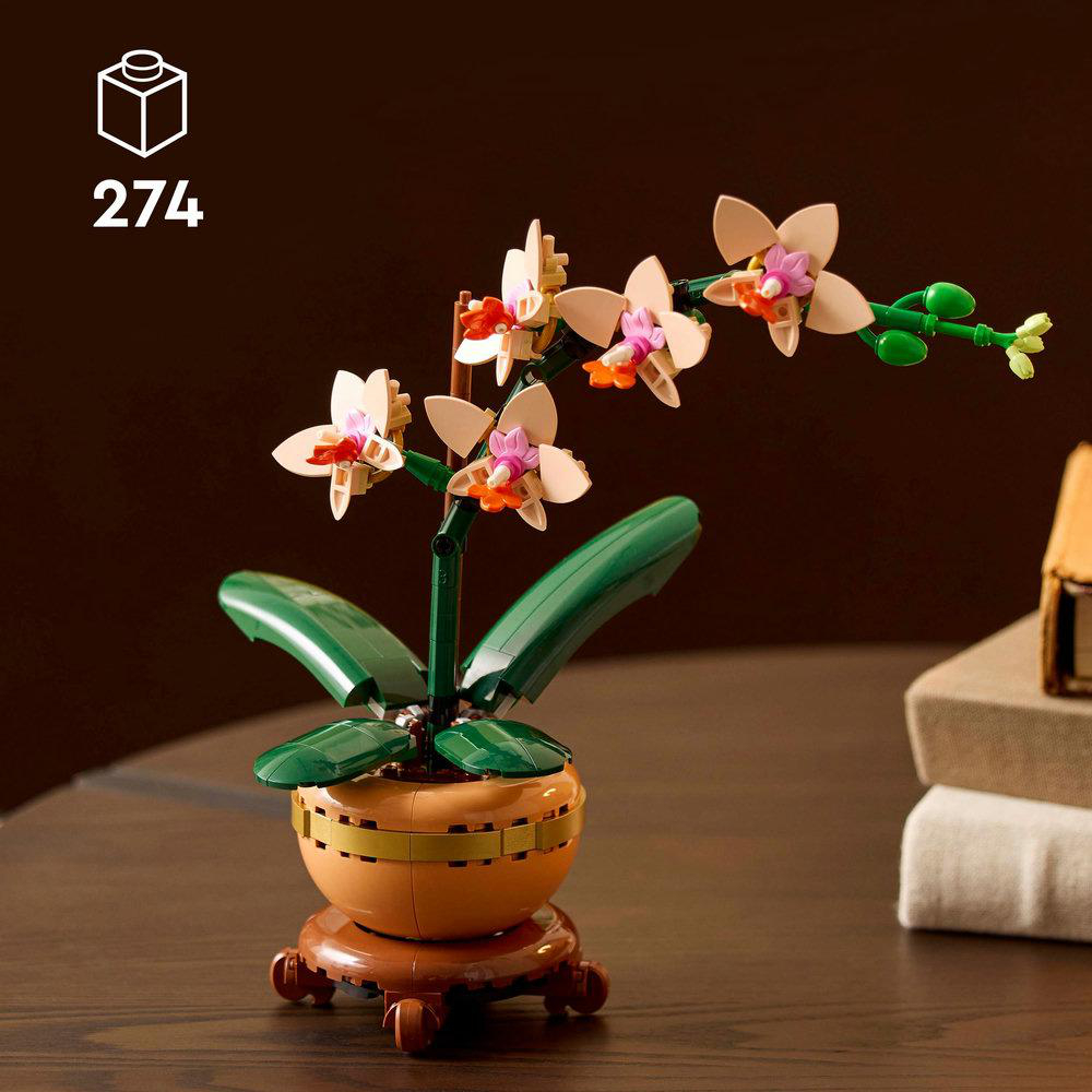Lego-Orchideenpflanze mit beigem Topf, braunem Ständer und grünen und pfirsichfarbenen Blüten.