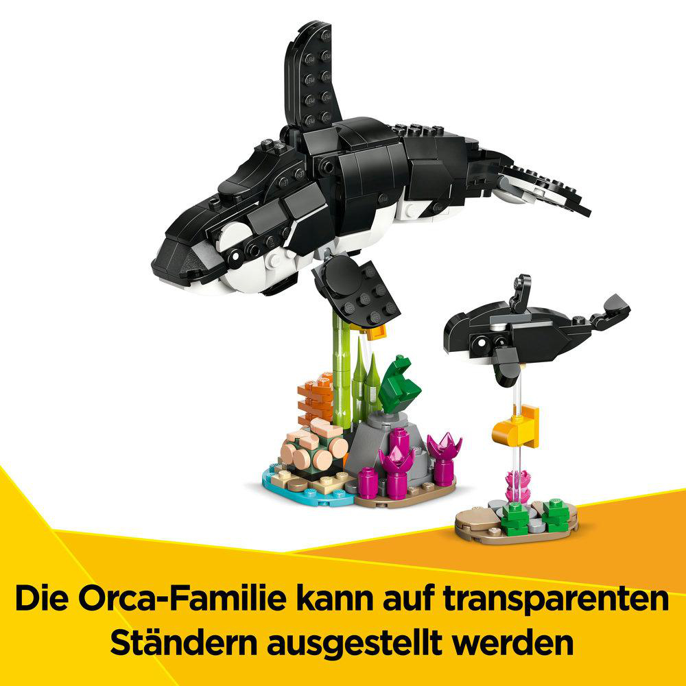 Lego Orca-Familie auf transparenten Ständern. Die Orca hat ein Baby. Die Basis ist mit Korallen und Seetang dekoriert.