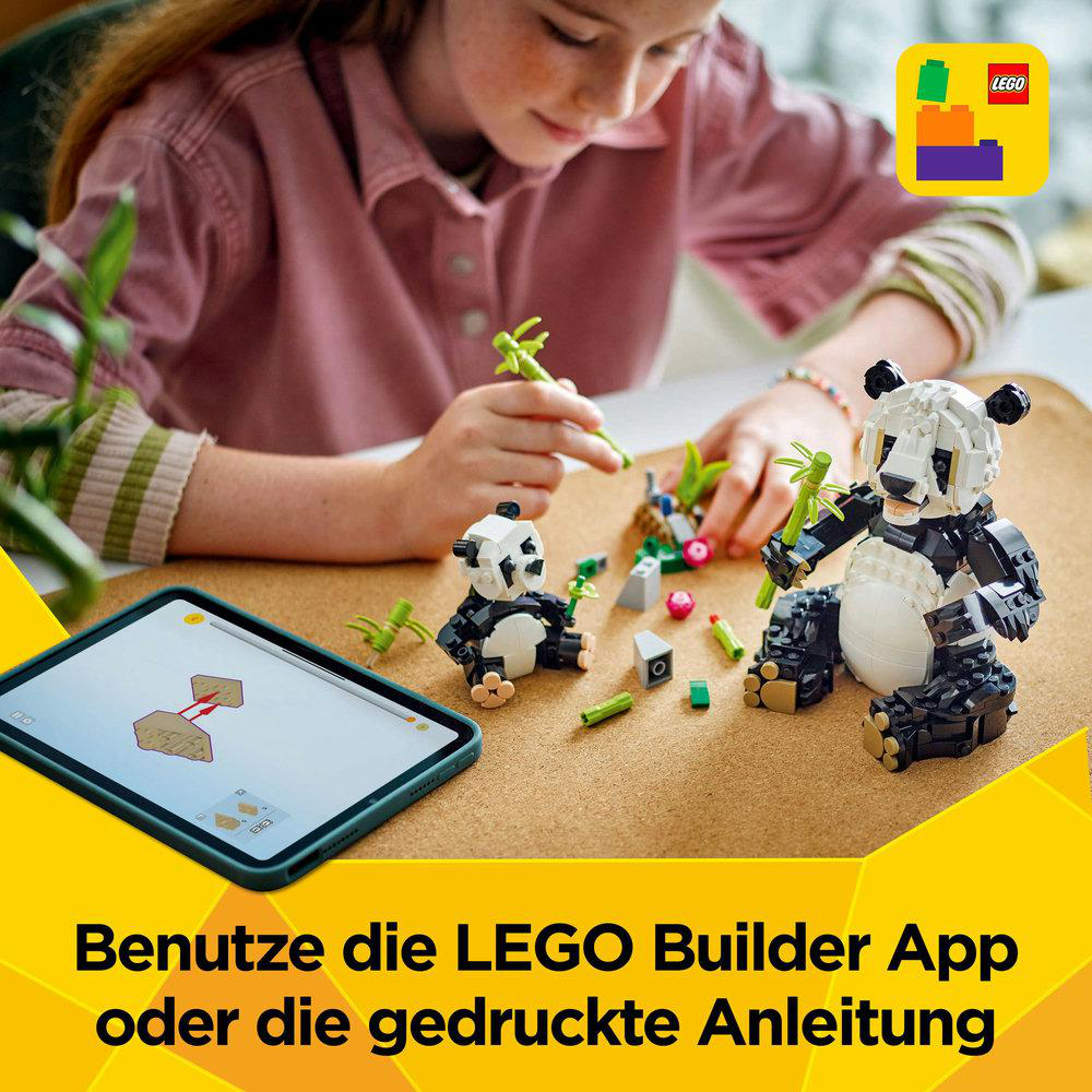 Ein Mädchen benutzt ein Tablet, um einen Lego-Panda zu bauen. Der Panda steht auf einem Tisch mit Lego-Steinen.