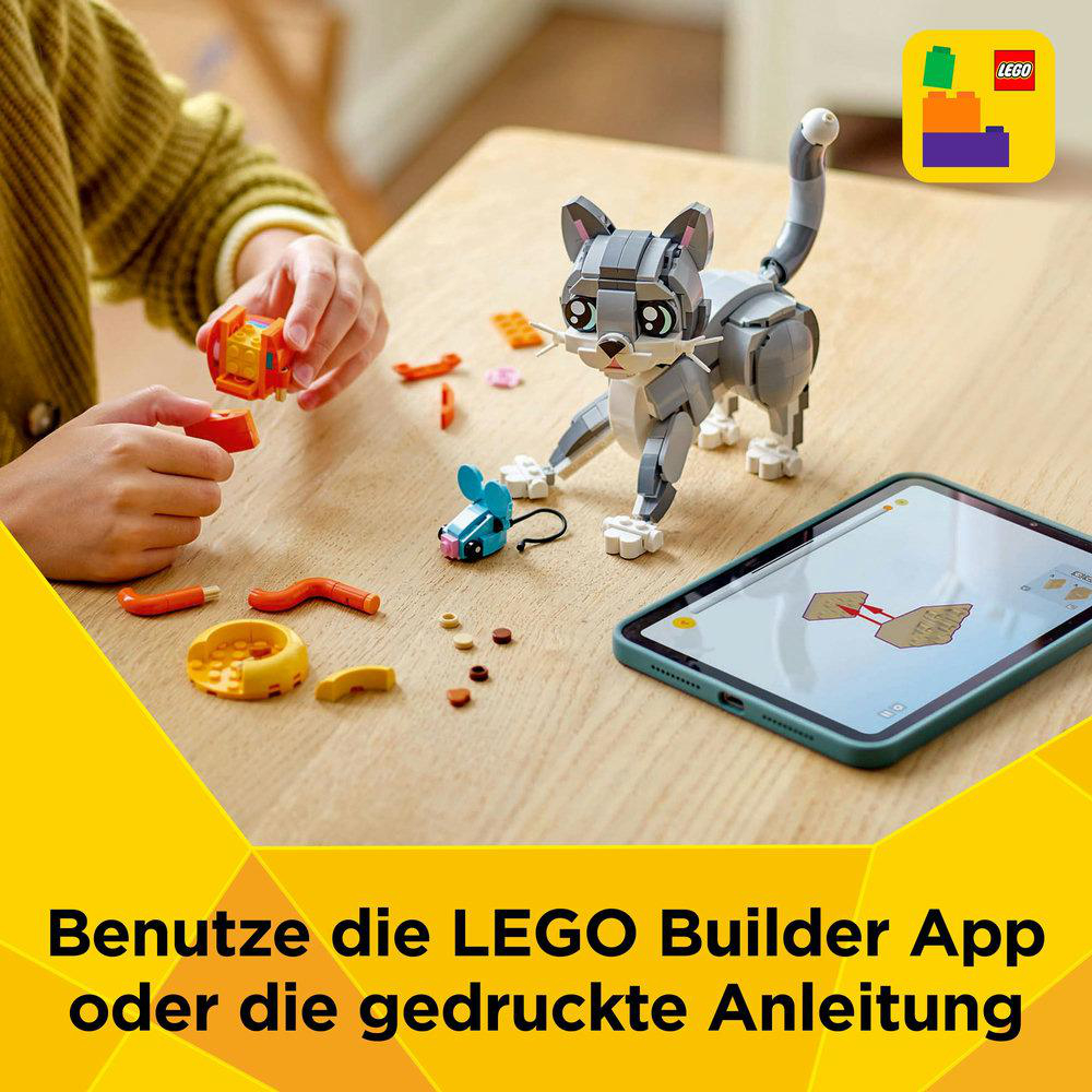 Ein Mädchen baut mit einem Tablet eine Lego-Katze. Die Katze ist grau, der Tisch hat Zubehör und Anweisungen auf dem Bildschirm.