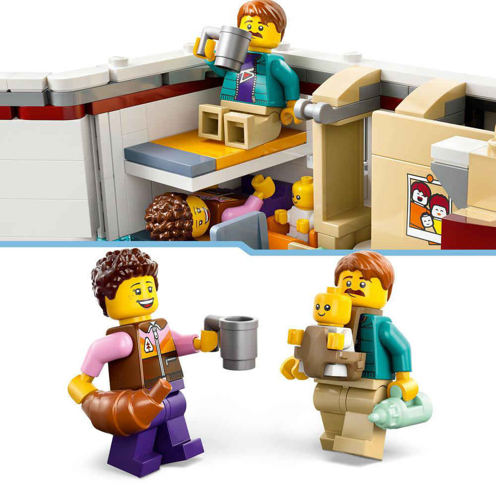 Lego-Figuren: ein Mann trinkt Kaffee, eine Frau hält ein Croissant, und ein Mann mit einem Baby.