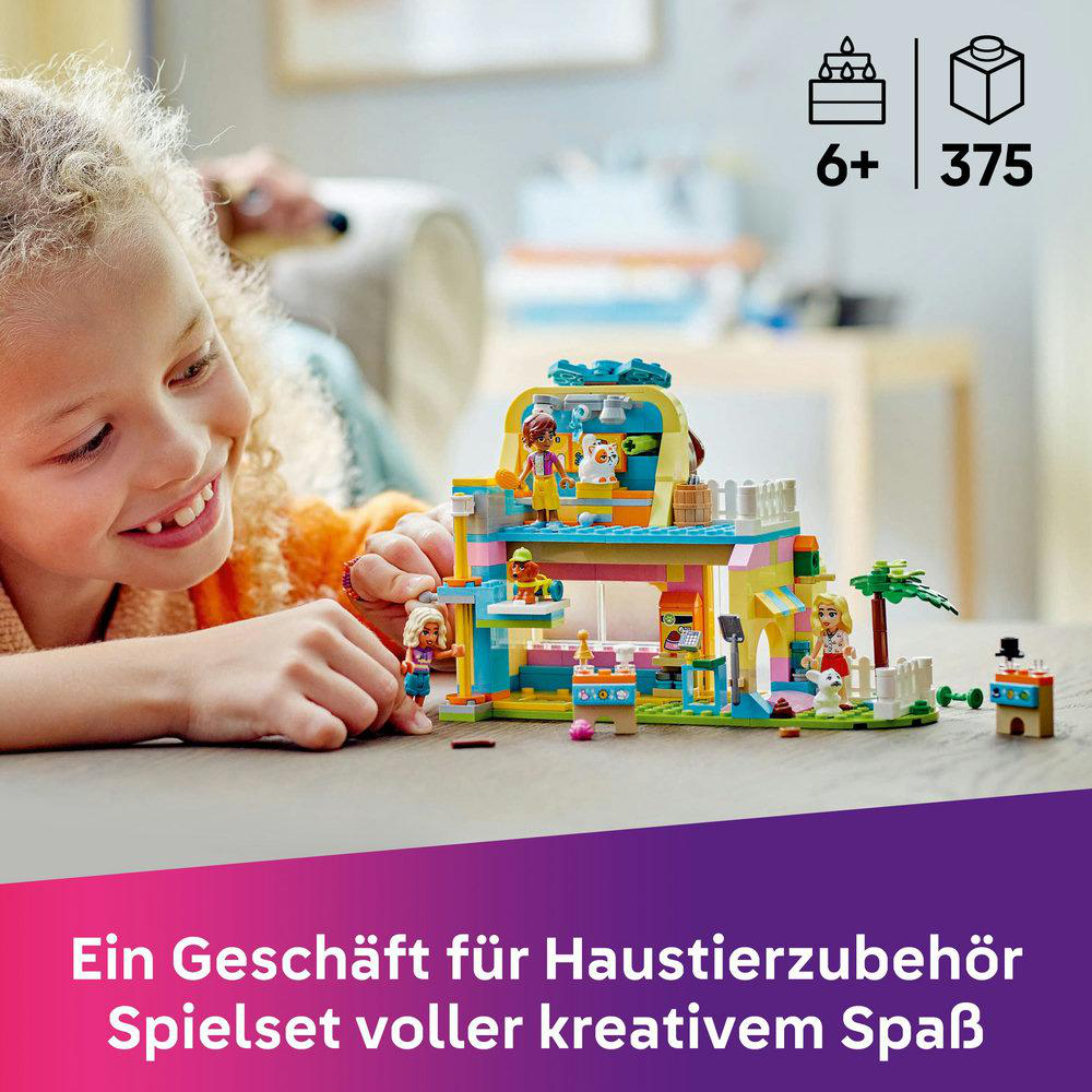 Ein Mädchen lächelt ein LEGO-Set mit Figuren an. Das Set zeigt ein Haus, Figuren und Dekorationen.