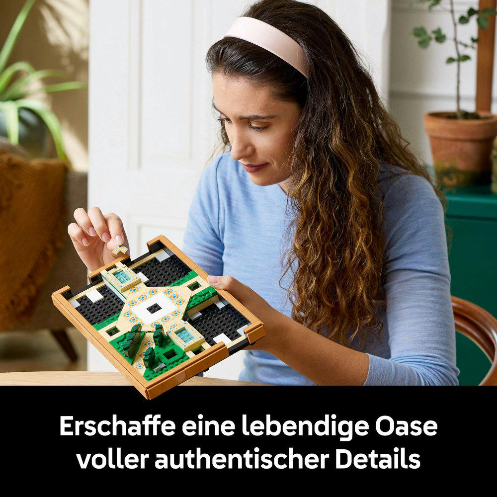 Eine Frau baut einen Lego-Garten. Das Garten-Set hat einen Brunnen, Bögen und Pflanzen. Sie lächelt.