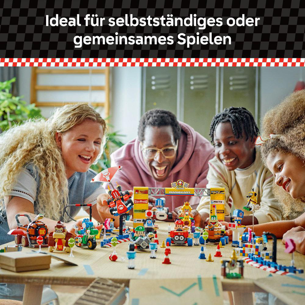 Vier Personen spielen mit einem bunten Spielzeugset auf einem Tisch.