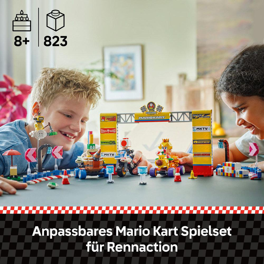 Zwei Kinder spielen mit einem Lego Mario Kart Set. Rennstrecke mit Minifiguren.