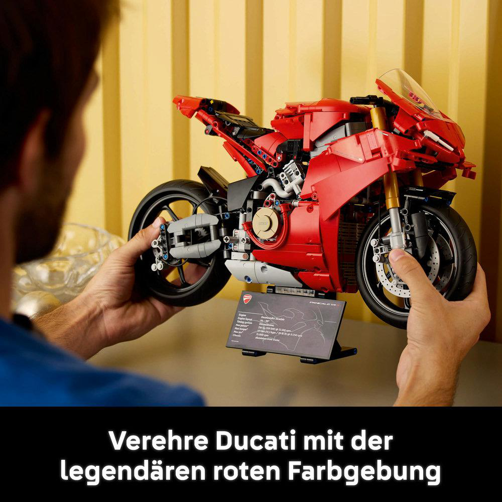 Hände, die ein rotes Ducati Motorrad LEGO Modell halten, mit Infokarte.