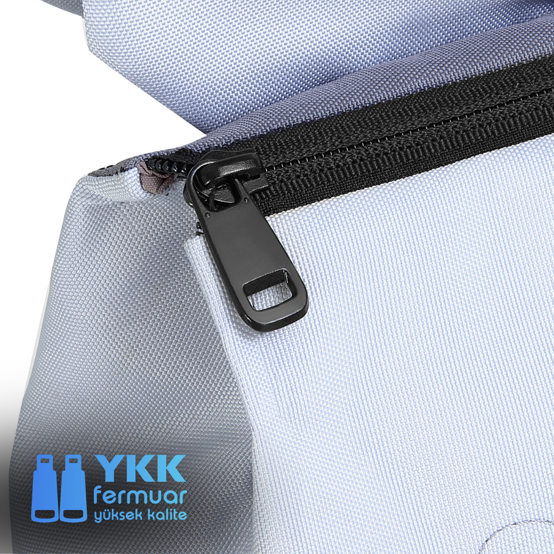 YKK etiketli siyah bir fermuarın yakın çekimi, fermuarı ve kumaşı gösteriyor.