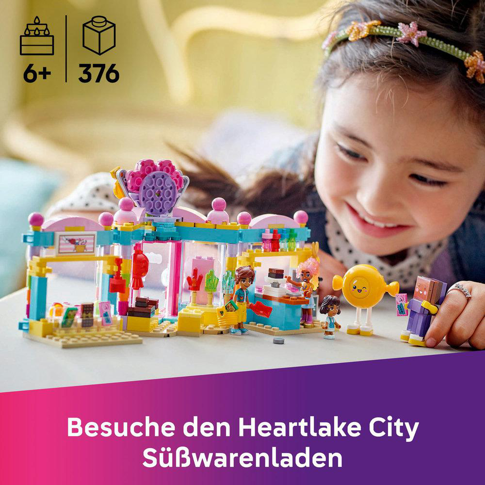 Ein Kind spielt mit einem Lego-Shop mit Minifiguren auf einem Tisch.