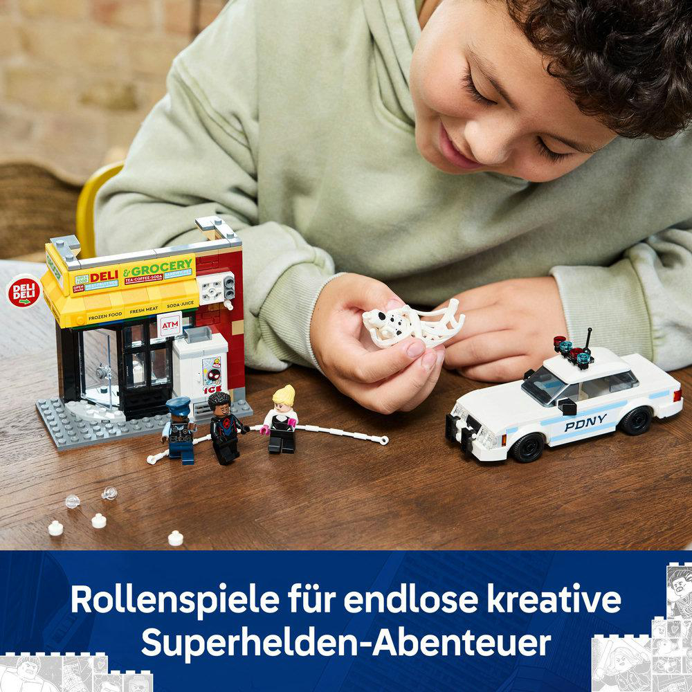 Ein Kind spielt mit einem LEGO-Set mit einem Polizeiauto, einem Feinkostladen und Minifiguren.