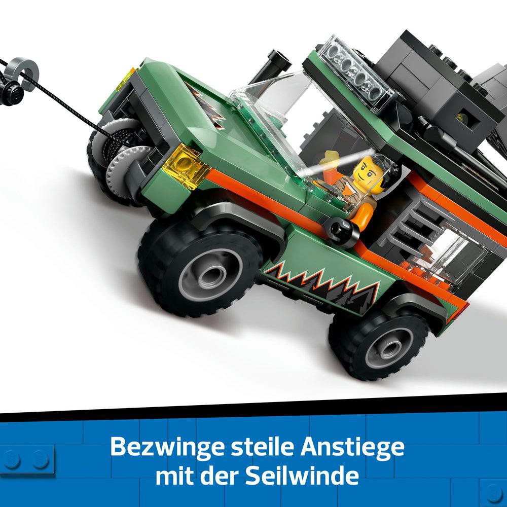 Ein grüner Lego-Truck zieht ein schwarzes Abschleppkabel. Eine Person fährt.