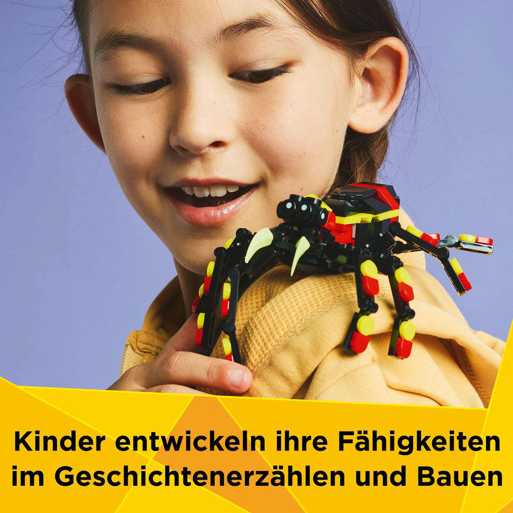 Ein Kind hält ein LEGO-Spielzeug, eine Spinne, mit anderen LEGO-Teilen in der Nähe.