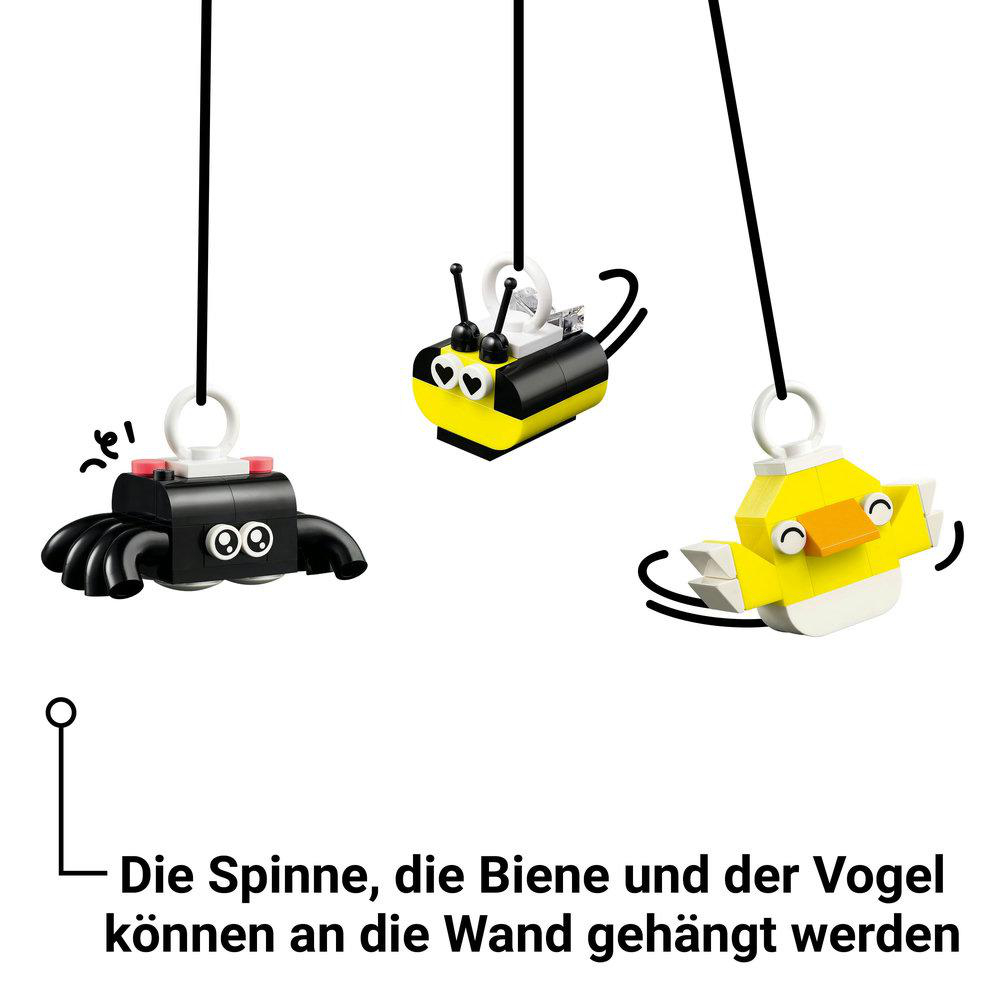 Drei Lego-Hängespielzeuge: Spinne, Biene und Vogel. Schwarze Schnüre hängen von oben.