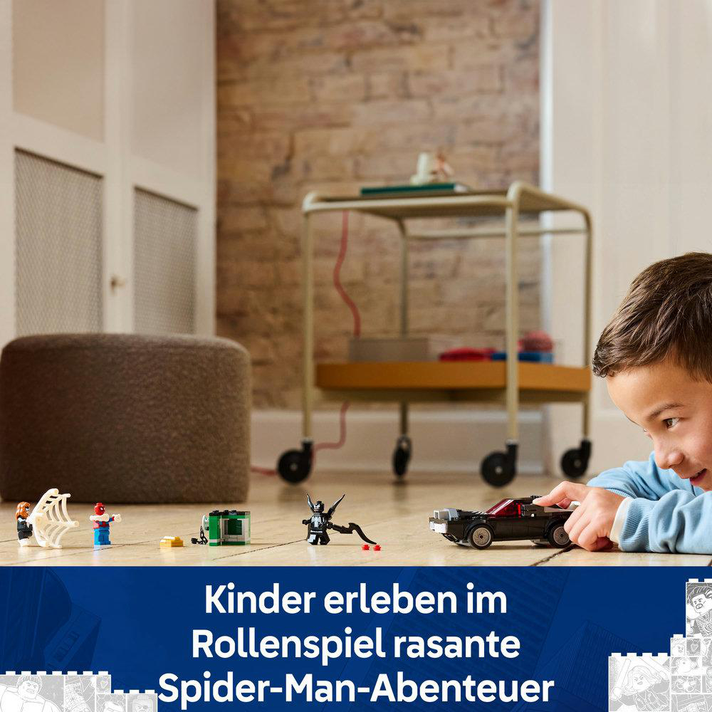 Ein Kind spielt mit Lego Spider-Man-Figuren auf einem Holzboden, mit einem Wagen im Hintergrund.