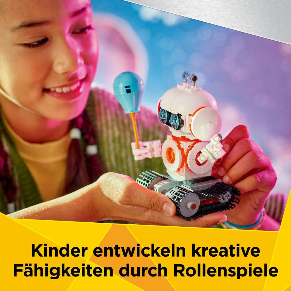 Ein junges Mädchen baut ein Roboterspielzeug. Der Roboter ist weiß mit orangefarbenen Details und einem blauen Ballon.